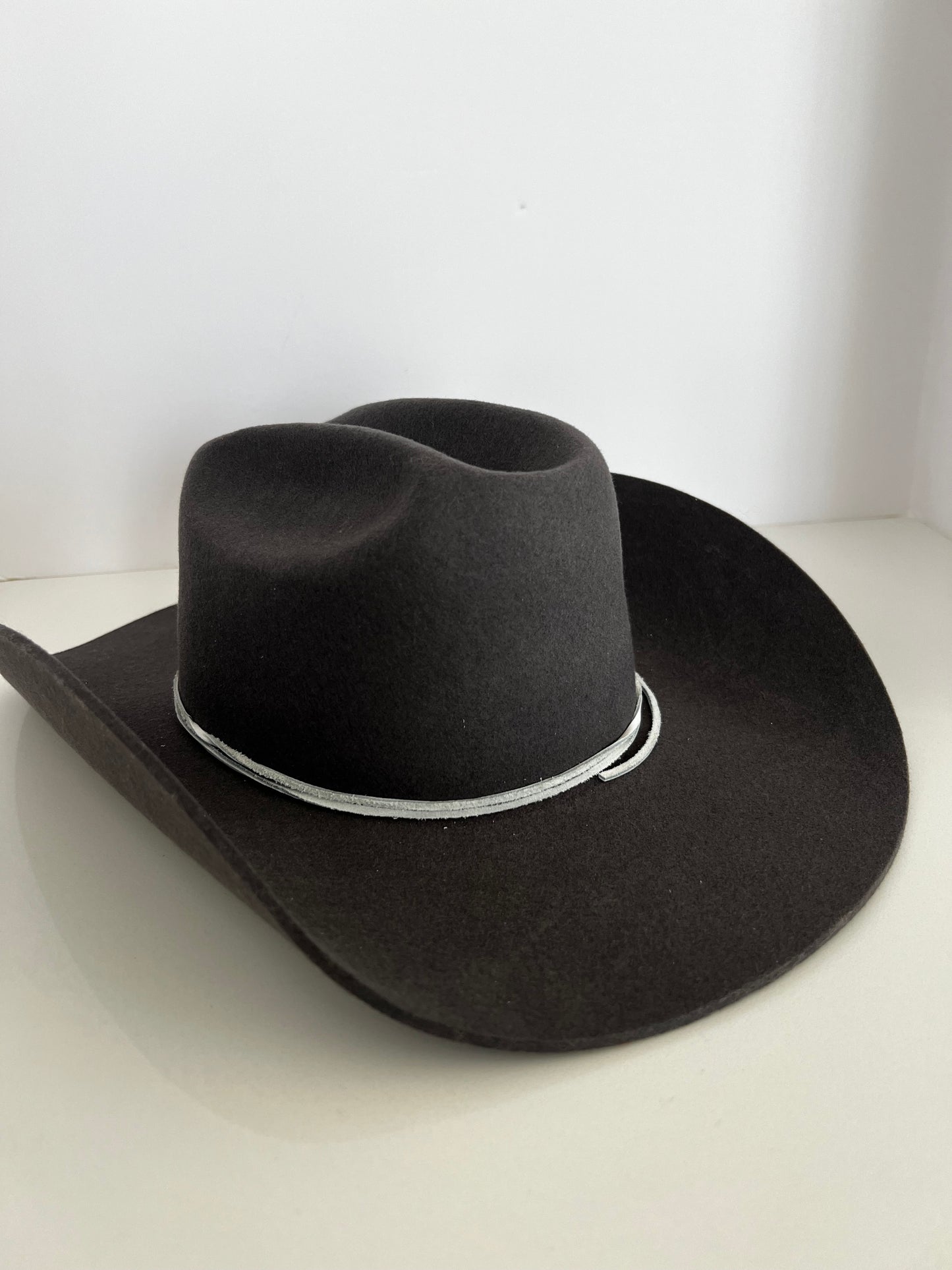 Grey felt cowboy hat with a wide brim and a silver-white braided band.