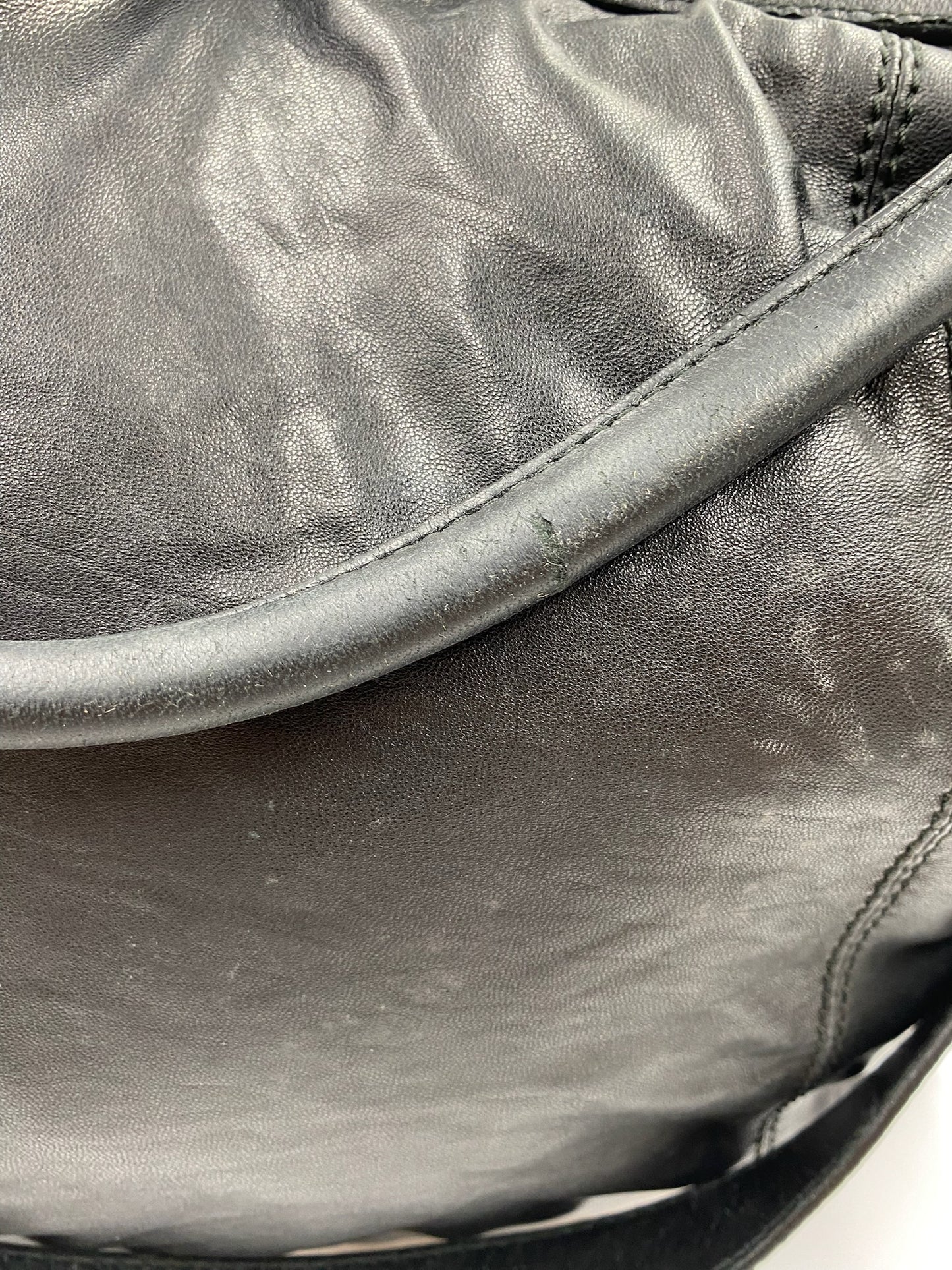 Close-up of a used Burberry Black Large Leather Handbag showing handle wear and textured leather.