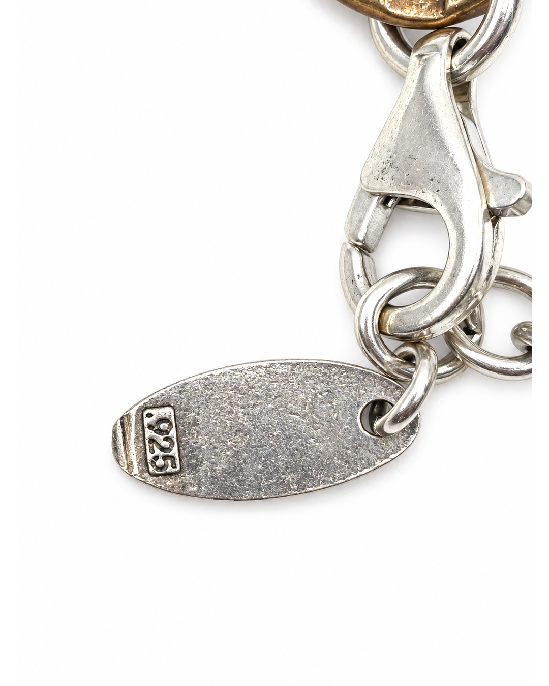 Karyn Chopik mixed metal bracelet featuring a silver lobster clasp and a textured oval charm stamped with 925 hallmark.