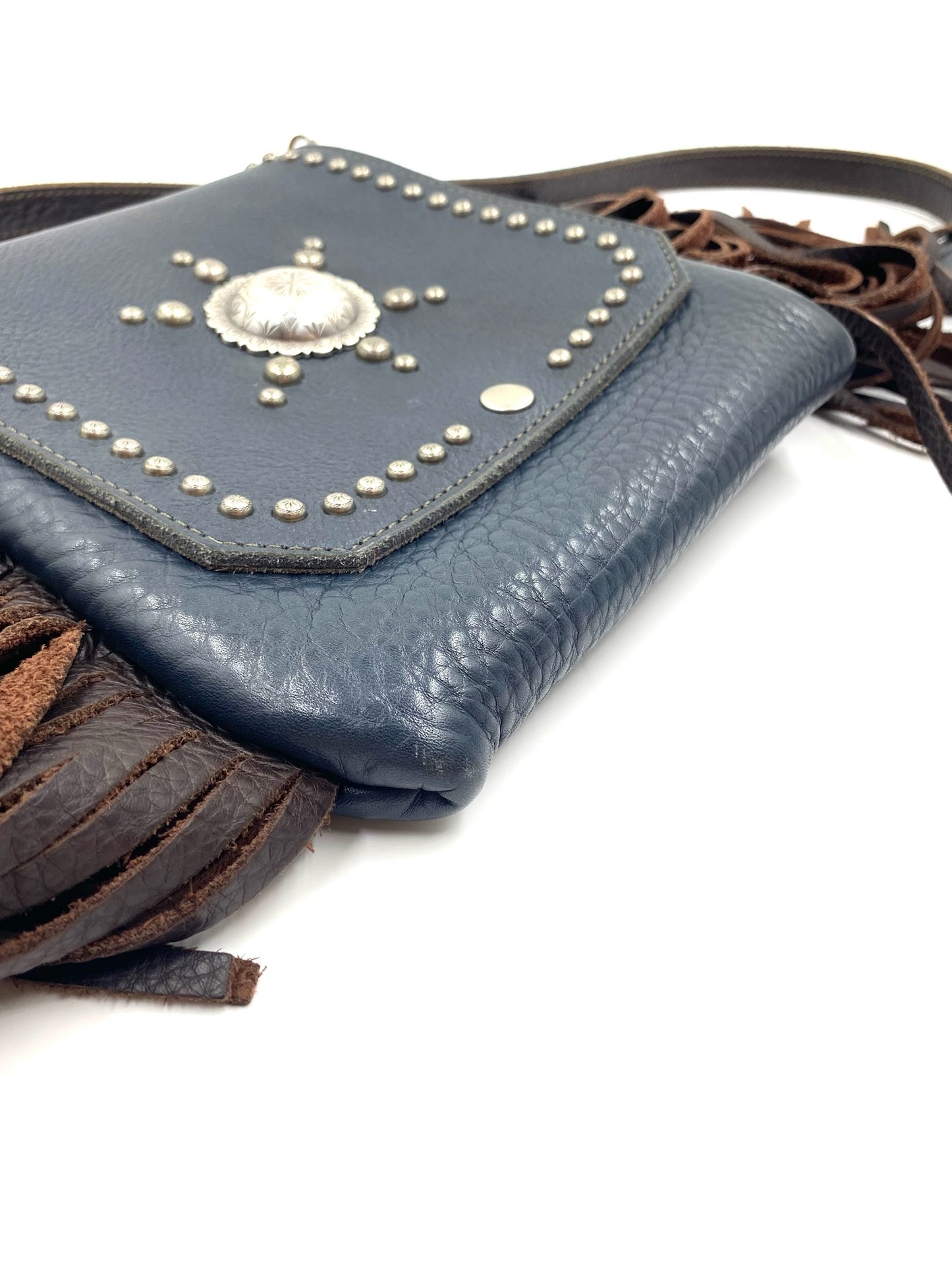 Navy fringe leather crossbody bag with silver stud details and a central concho.