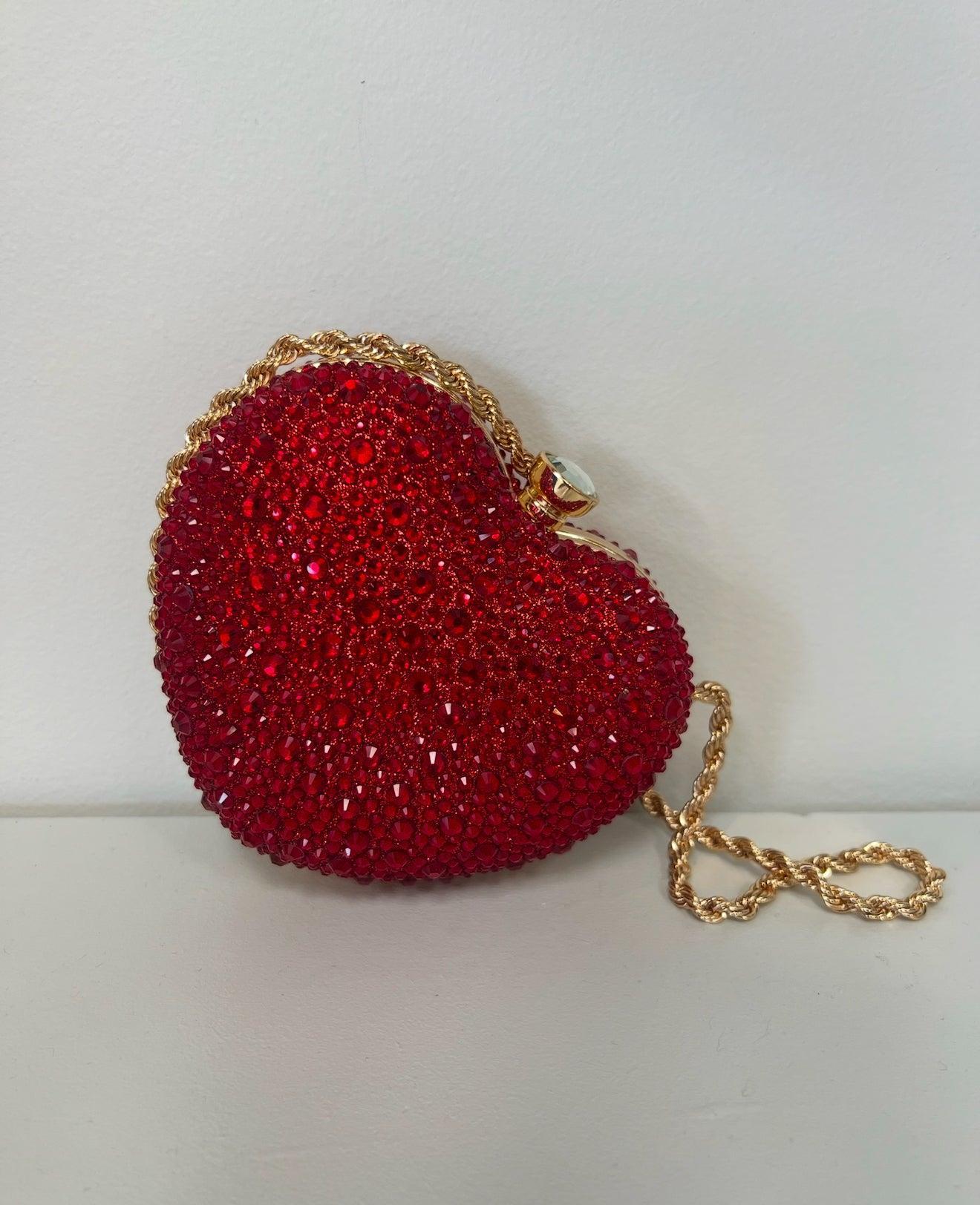Red heart-shaped clutch covered in sparkling red crystals with a gold chain strap and clasp.