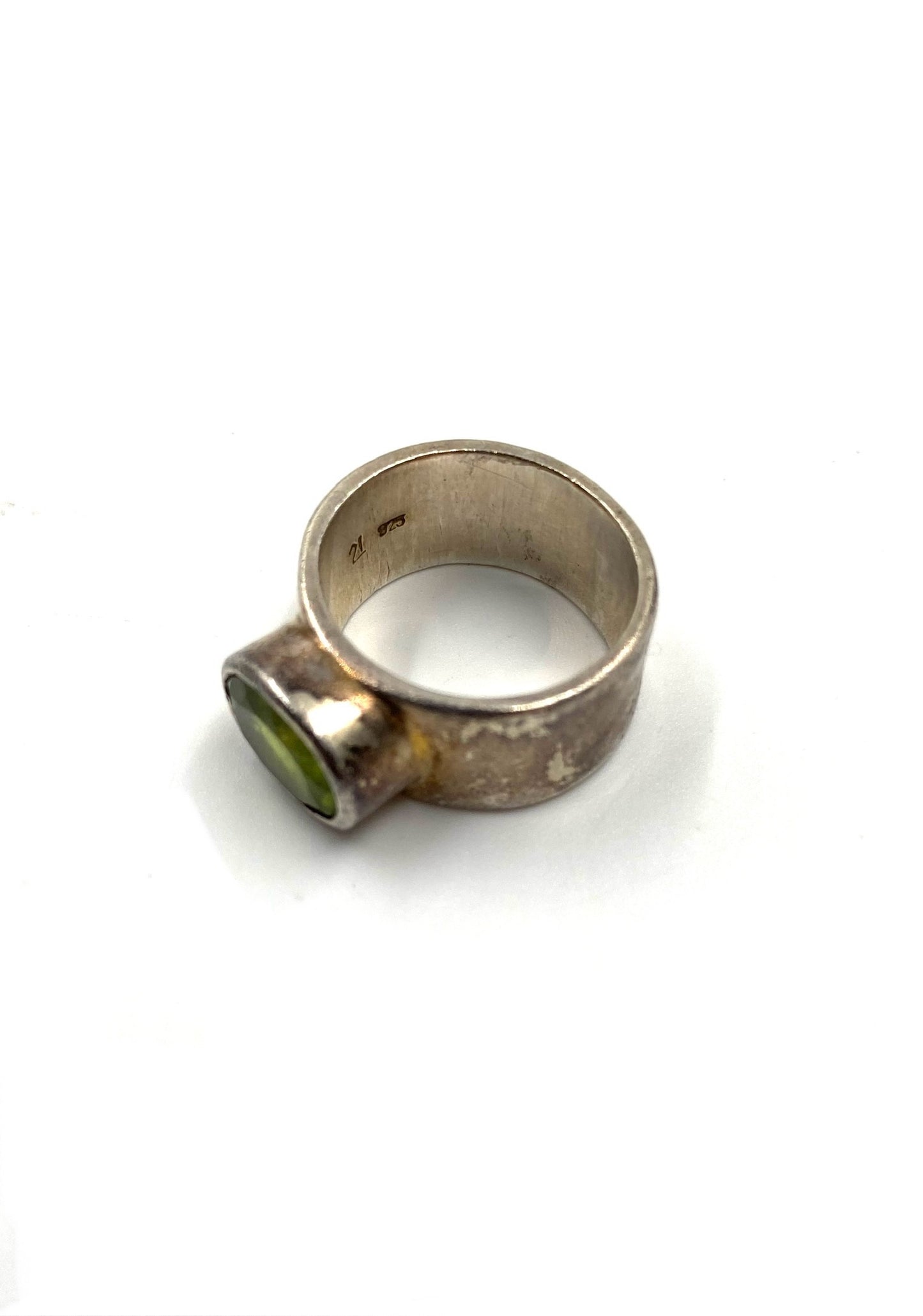 Sterling silver ring with an oval peridot gemstone, size 7.25, on a white background.