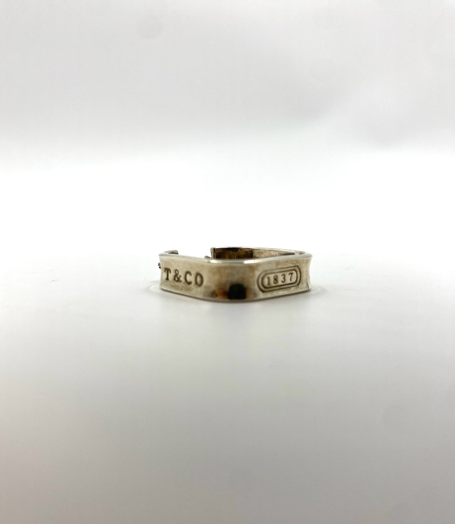 Tiffany & Co 1837 sterling silver square earring with "T&CO" and "1837" engravings.