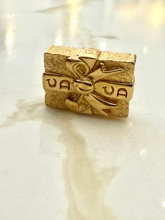 Vintage 90s Christian Dior gold-tone gift box pin brooch with a textured finish and bow detail.