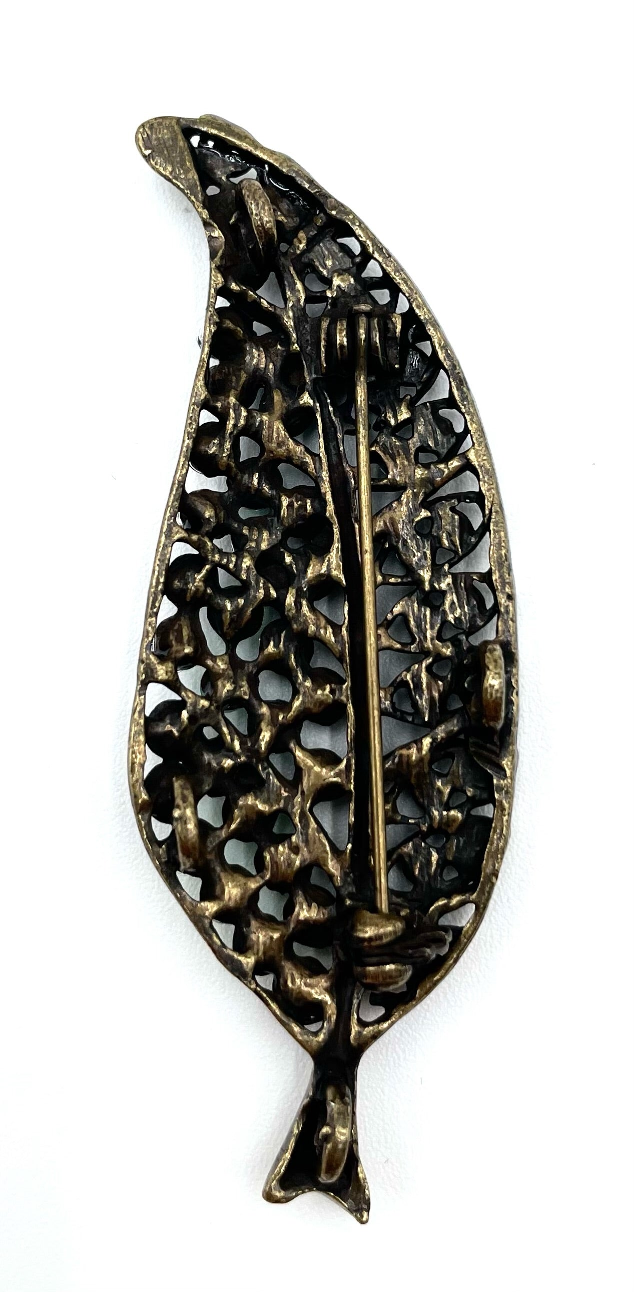 Back of a vintage green rhinestone leaf brooch with an antique gold-tone finish and pin closure.