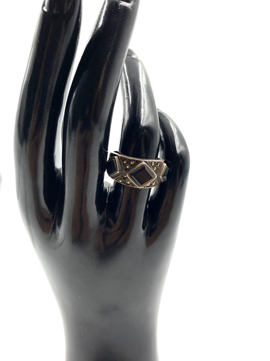 Sterling silver ring size 7 with a square black onyx stone and marcasite accents on a black display hand.