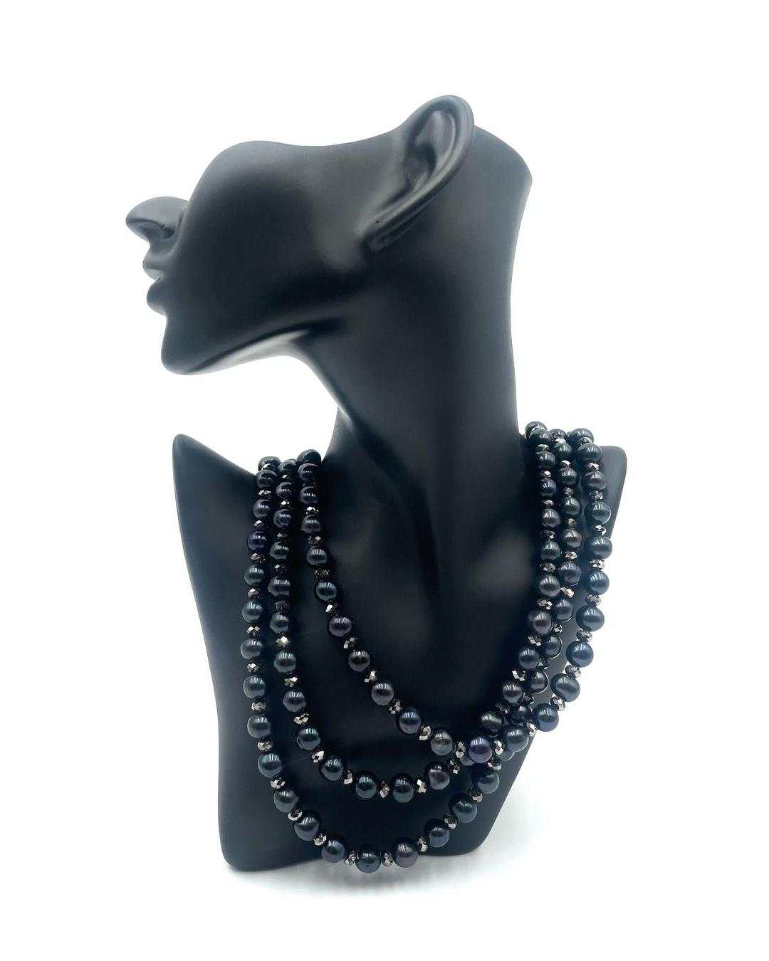 Triple strand necklace featuring black pearls and sparkling Swarovski crystals on a black mannequin display.