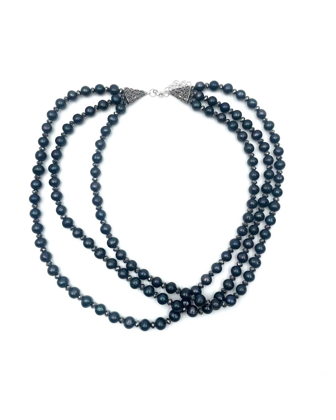 Triple strand necklace featuring black pearls and sparkling Swarovski crystals with ornate silver-tone clasps.