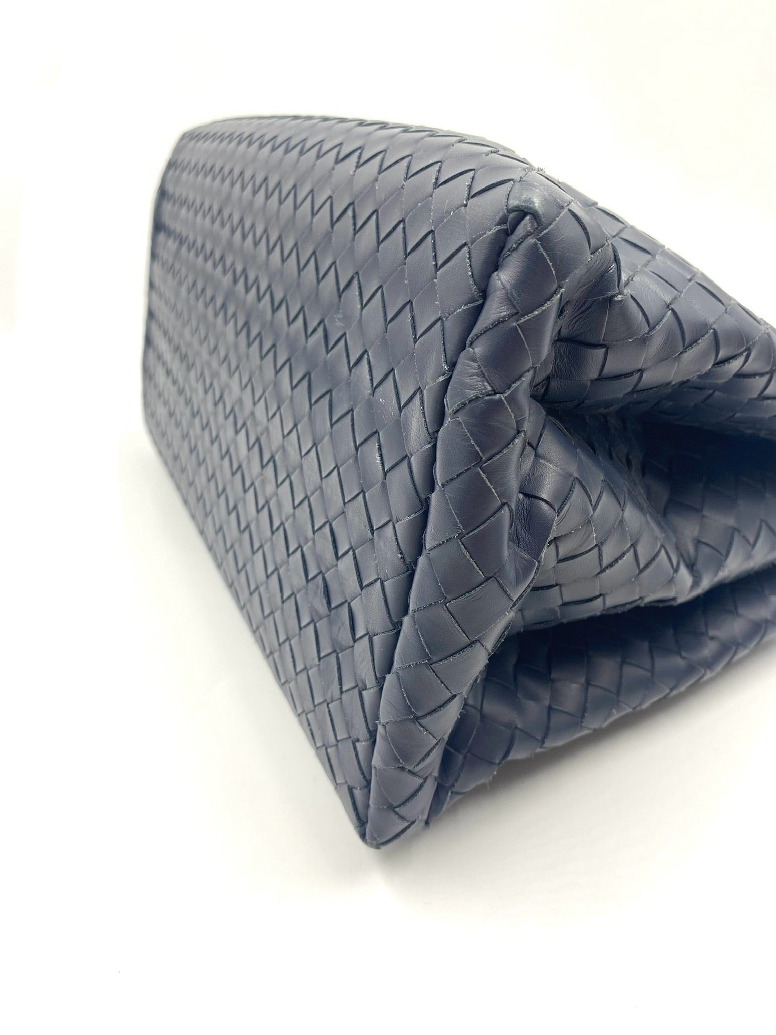 Bottega Veneta blue Intrecciato leather small Roma bag, showing woven texture and side profile.
