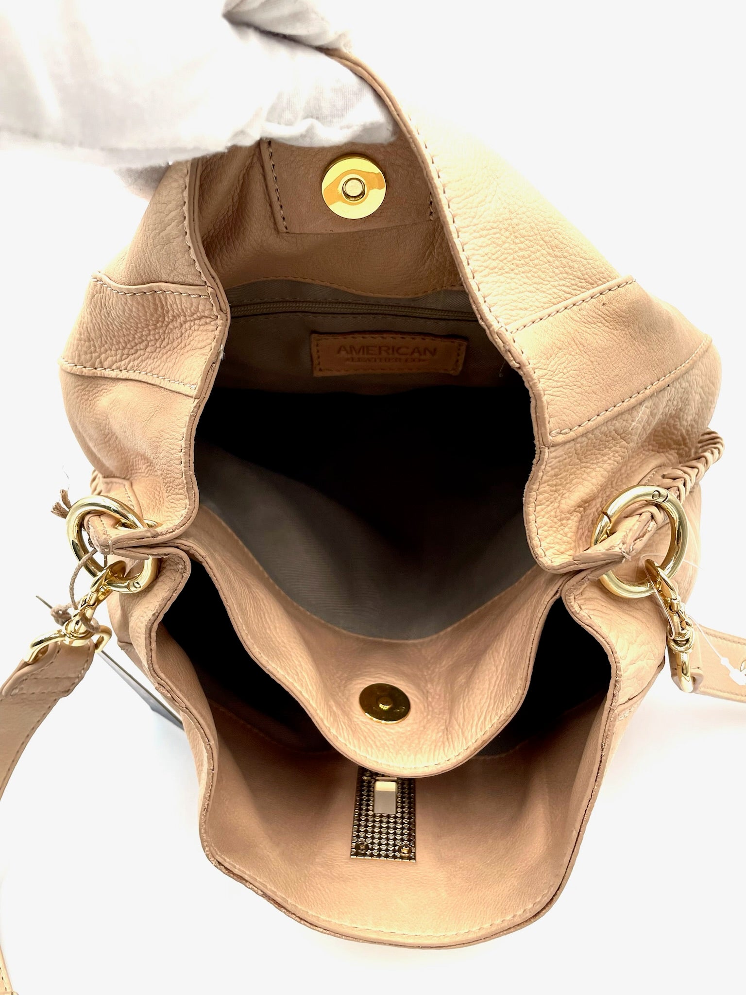 Open American Co biege leather shoulder bag with gold hardware, braided sides, and magnetic snap closure.