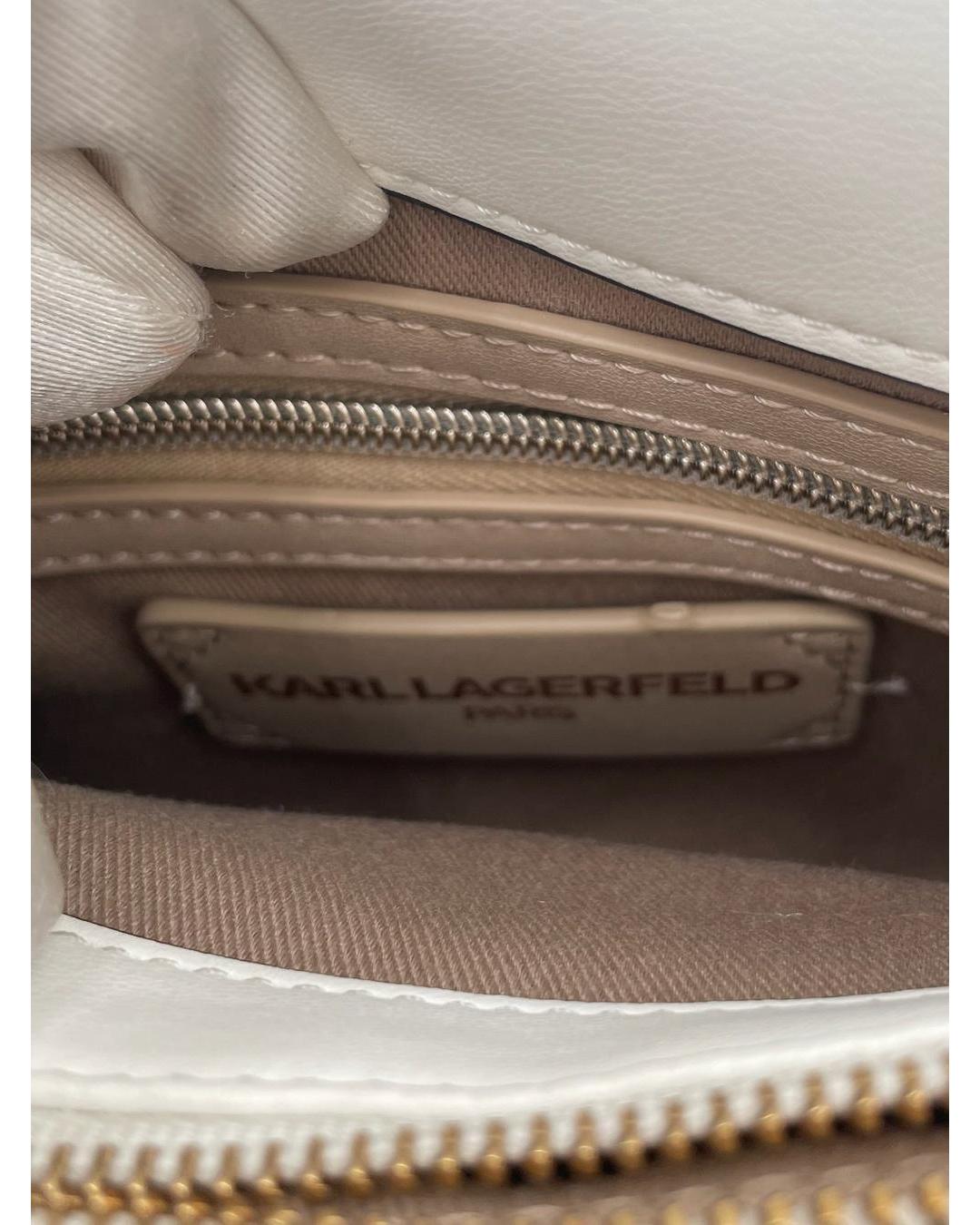 Interior of a cream Karl Lagerfeld Lafayette bag showing a branded leather patch, zip compartment, and fabric lining.