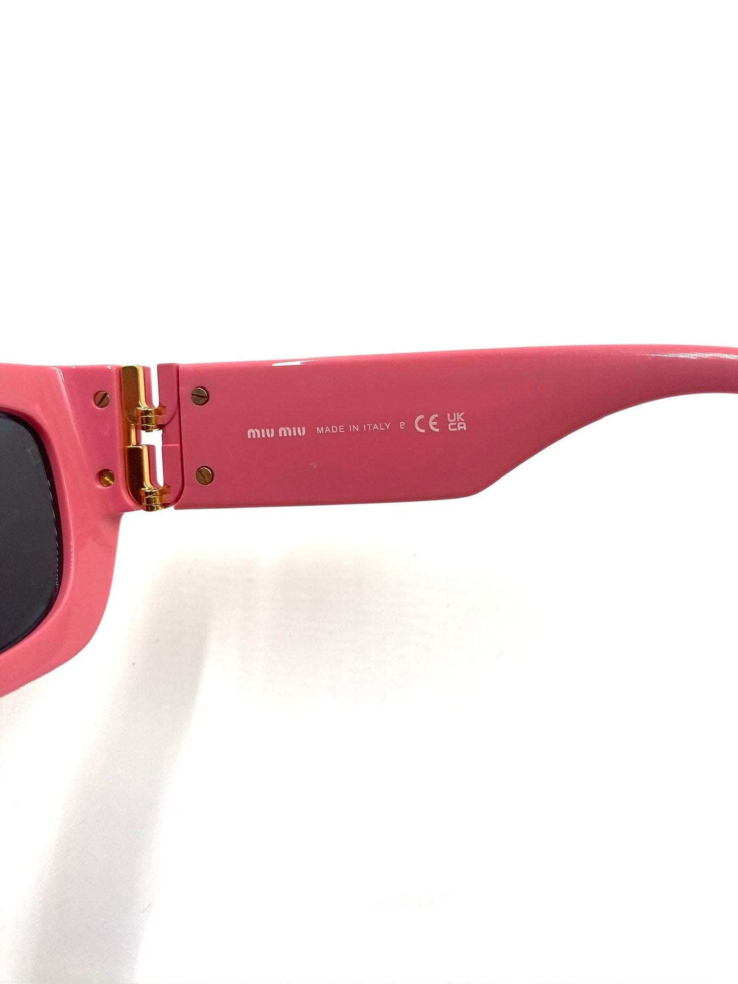 Miu Miu pink rectangular sunglasses with gold-tone hinges and "MADE IN ITALY" engraved on the temple.