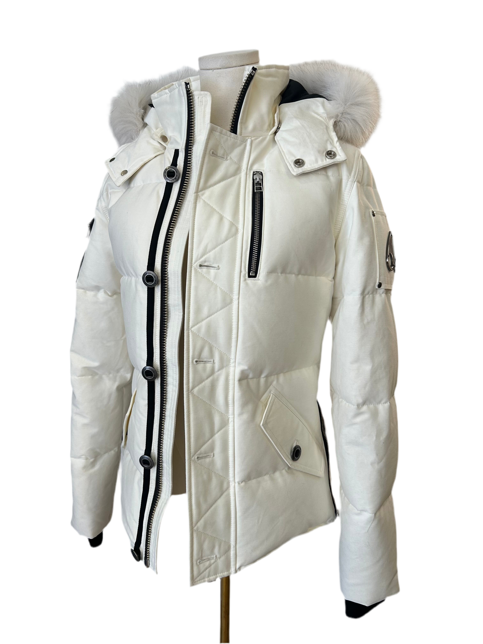 Moose Knuckle Women's White Down Puffer Jacket, size XS, with fur-trimmed hood and black accents.