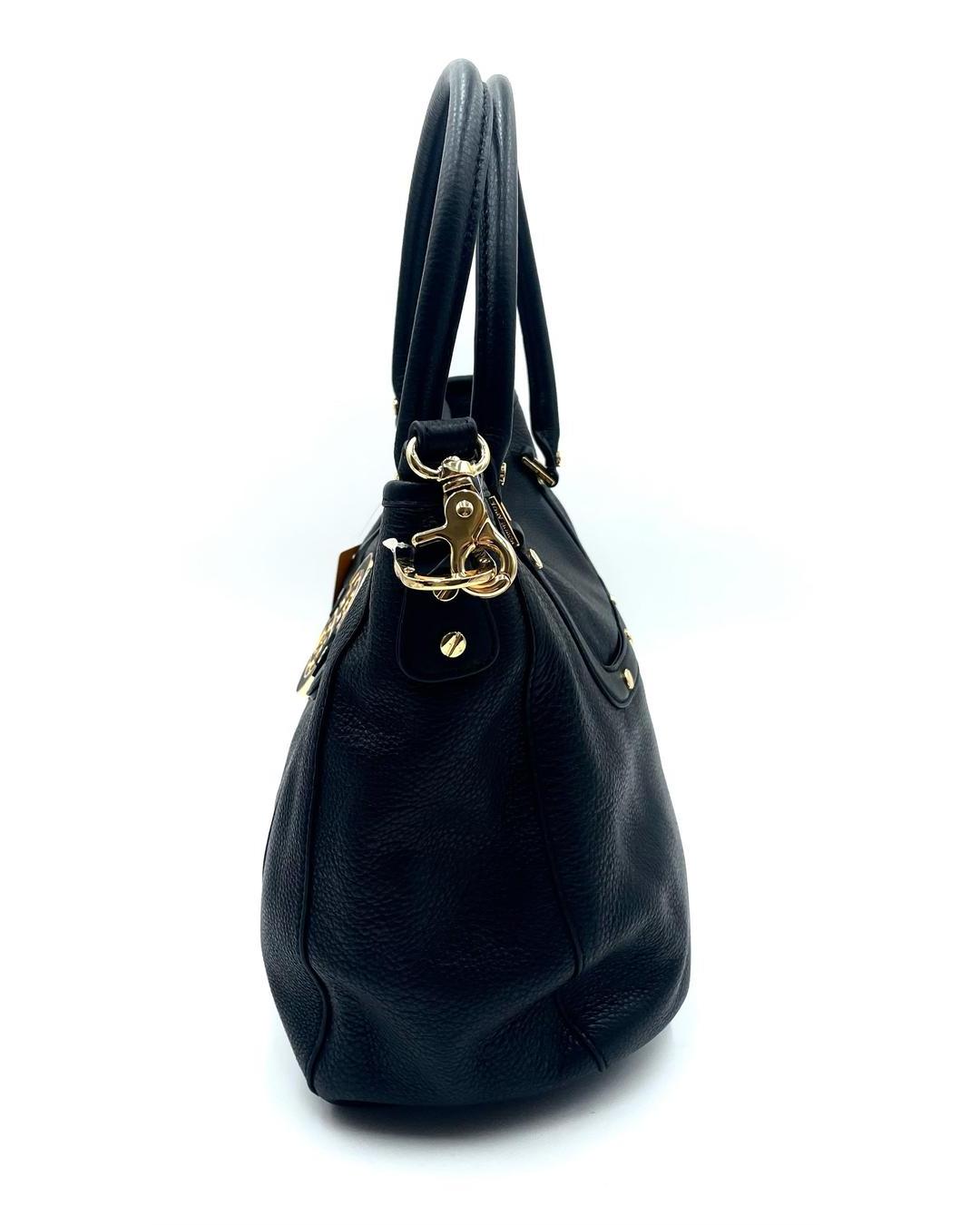 Side view of a black pebbled leather Tory Burch Amanda hobo bag with gold-tone hardware and a detachable shoulder strap.