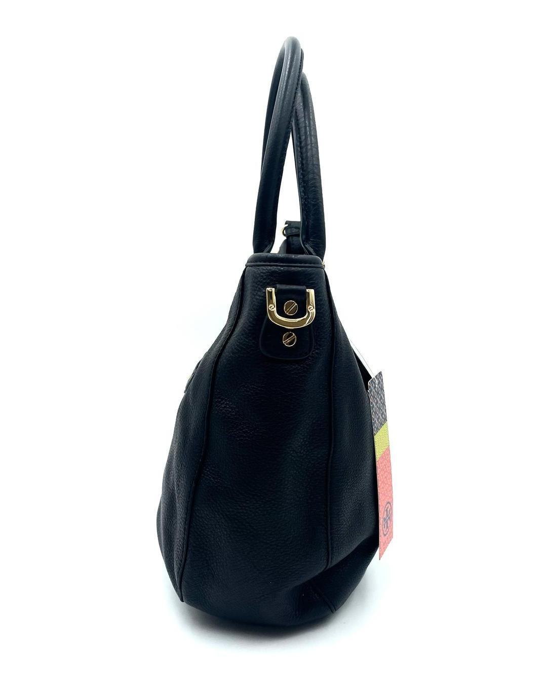 Side view of a black pebbled leather Tory Burch Amanda hobo bag with gold-tone hardware and a brand tag.