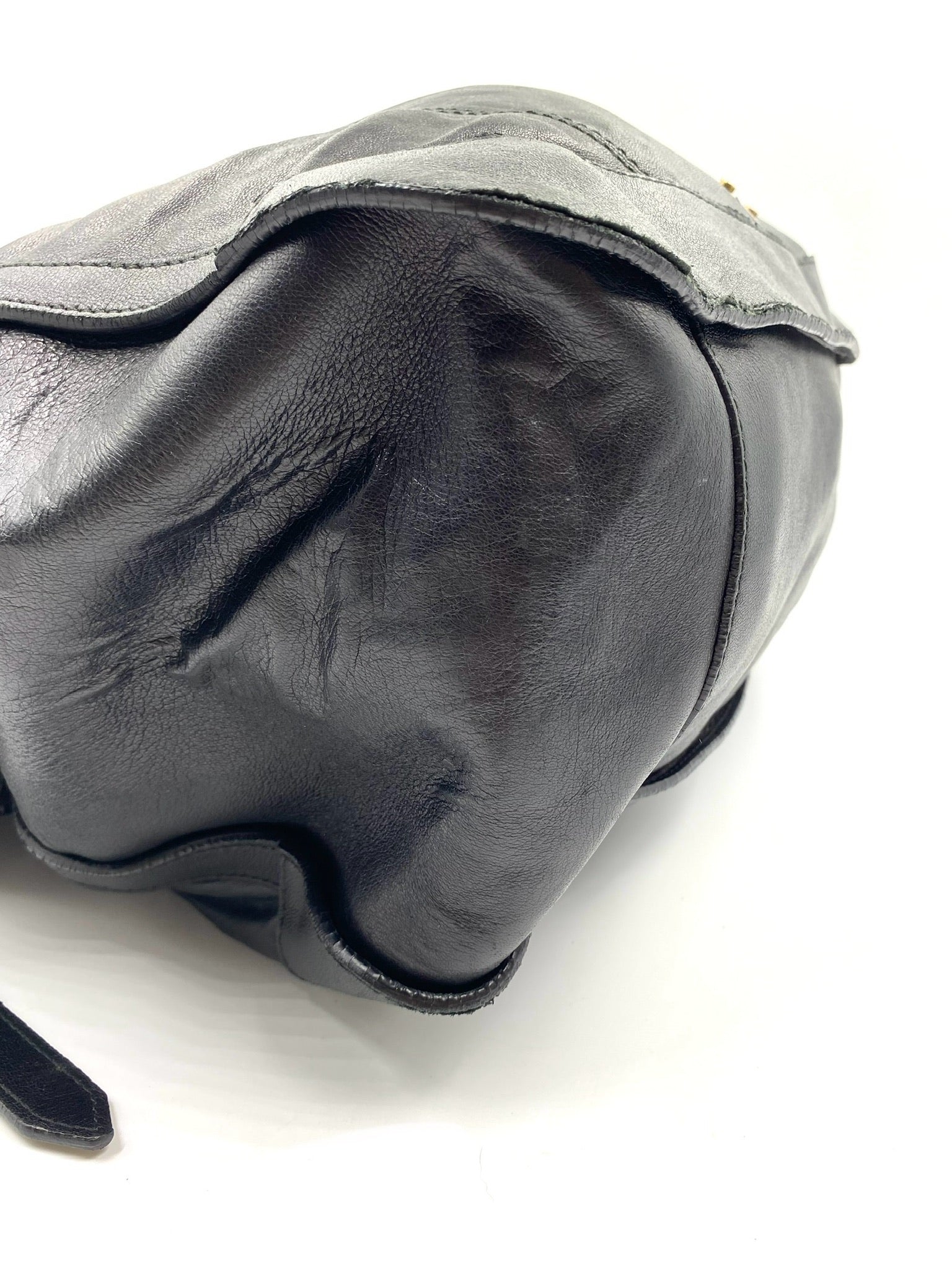 Close-up of a used Burberry Black Large Leather Handbag, showing corner wear and textured black leather.