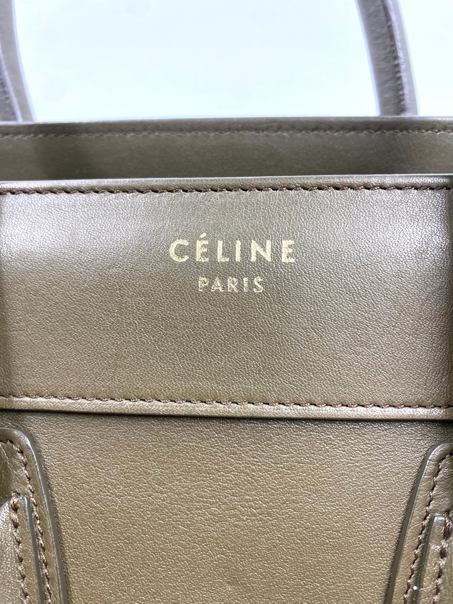 Close-up of Celine Olive Calfskin Micro Luggage Tote with gold "CÉLINE PARIS" logo.