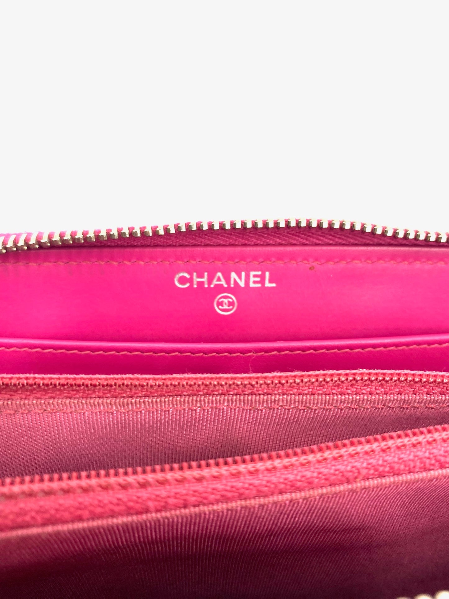 Chanel Pink Long Caviar Zip Wallet interior, showing logo, silver hardware, and compartments.