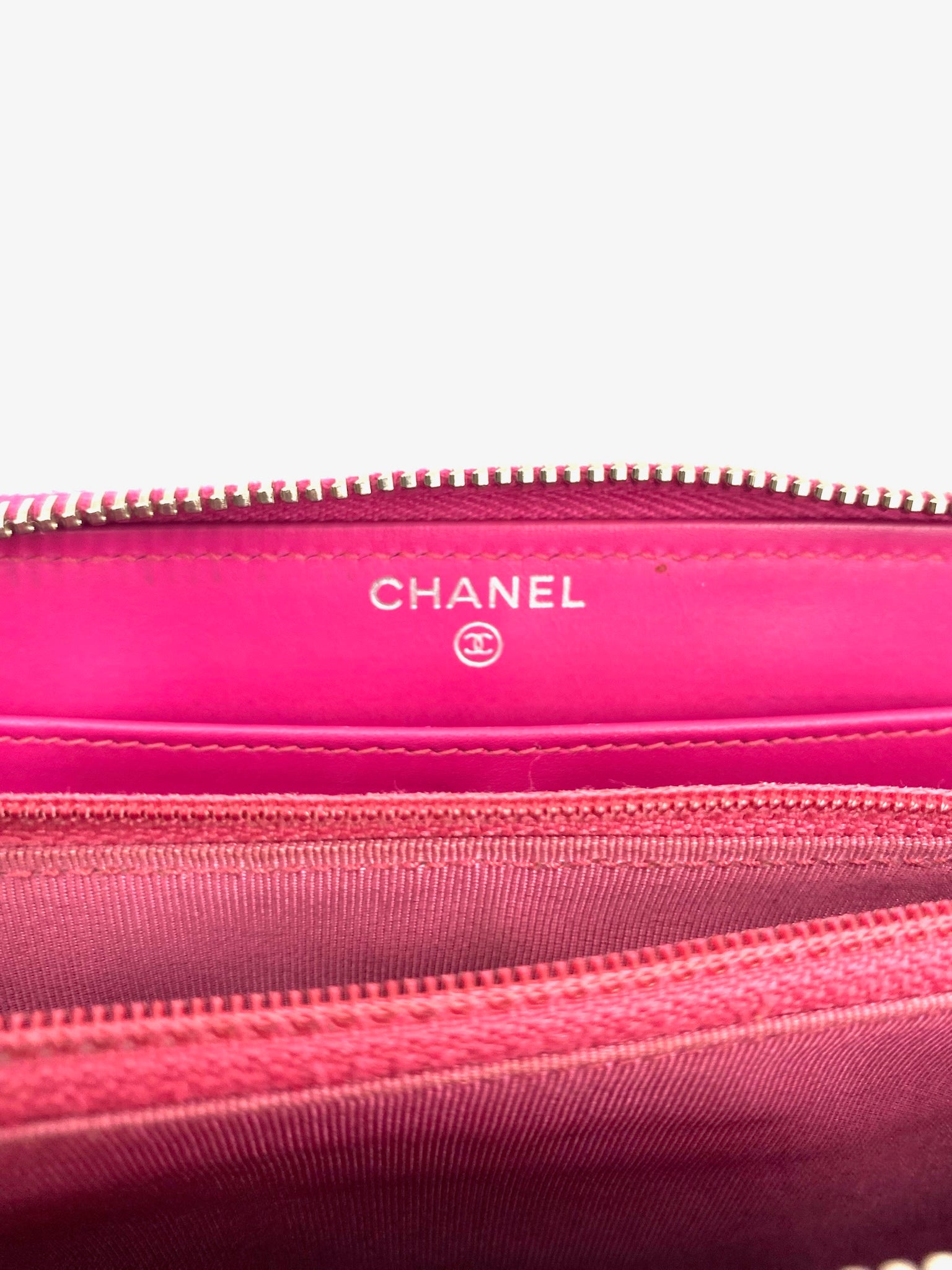 Chanel Pink Long Caviar Zip Wallet interior, showing logo, silver hardware, and compartments.