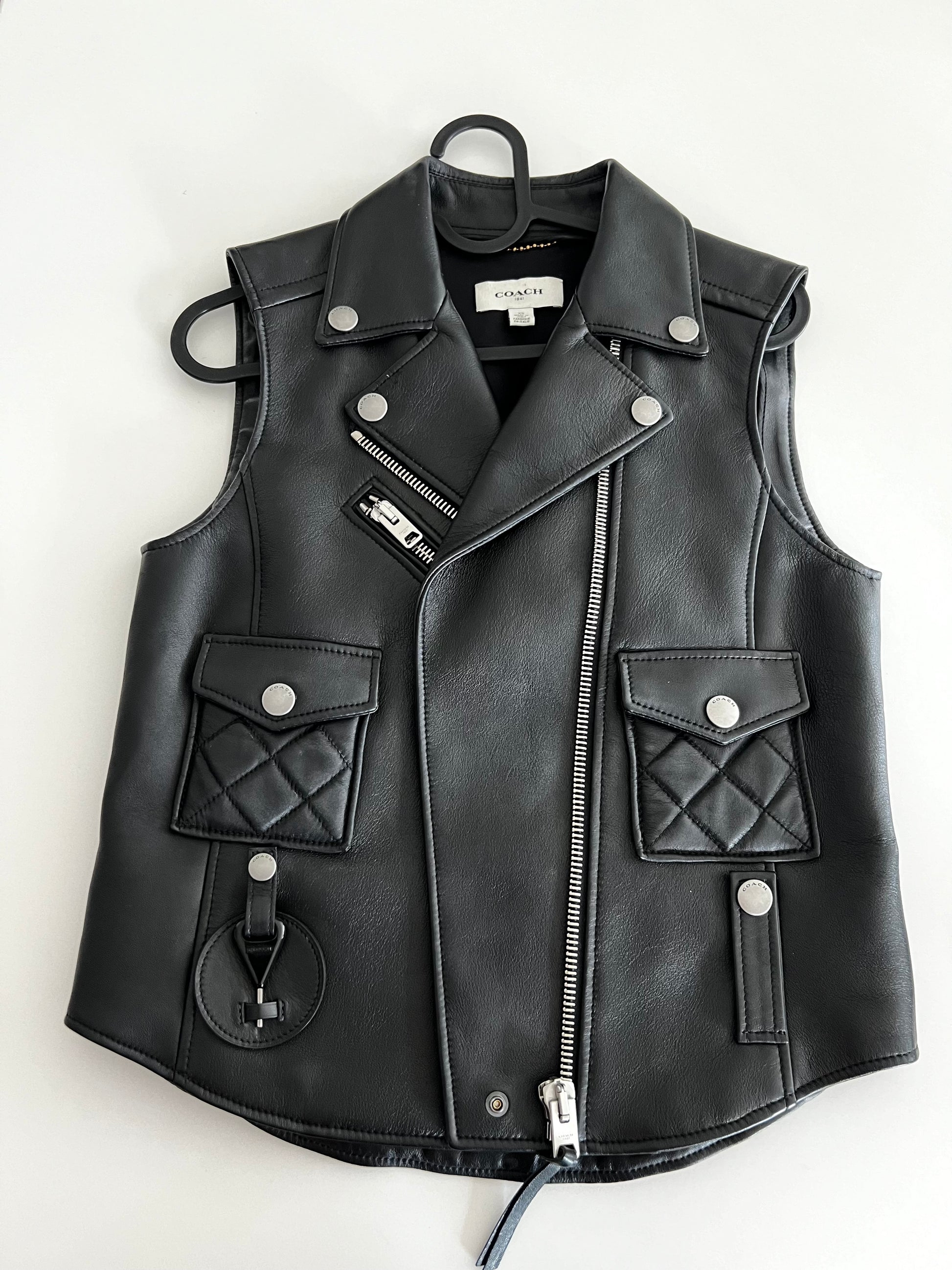 Coach 1941 black leather biker vest, size XS, with silver zippers, snap buttons, and quilted pockets.