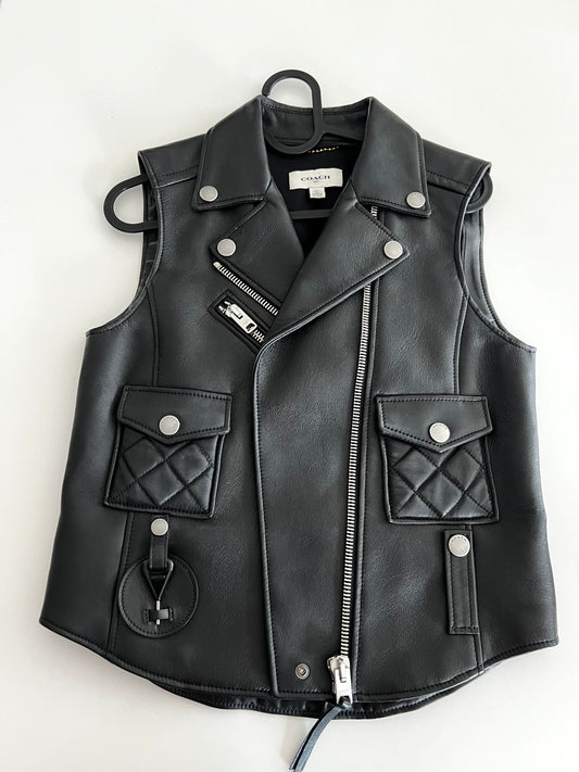 Coach 1941 black leather biker vest, size XS, with silver zippers, snap buttons, and quilted pockets.