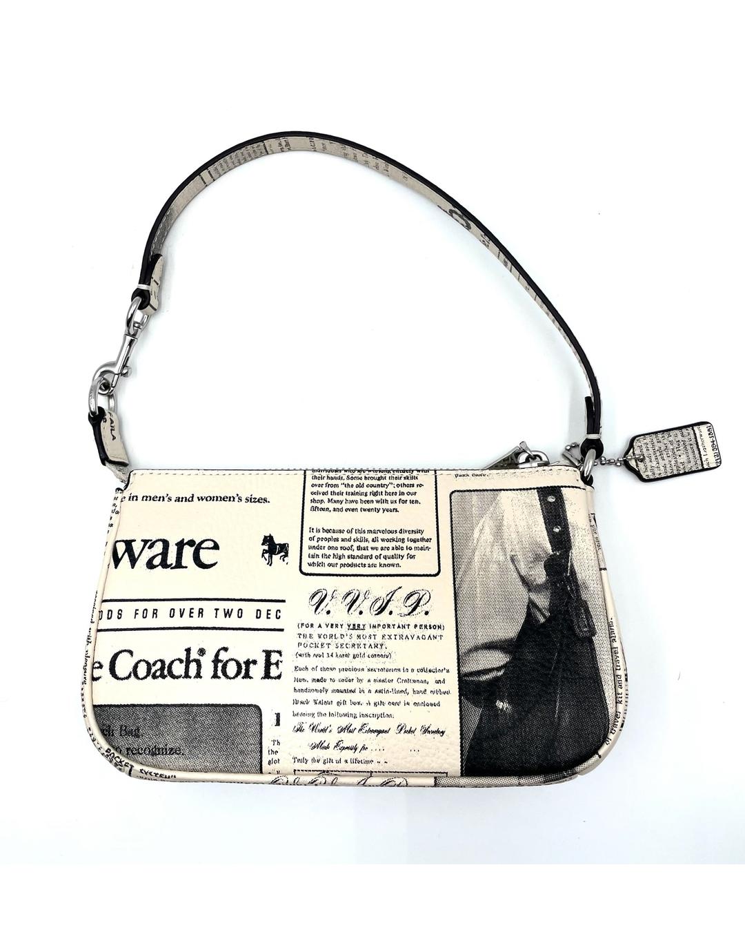 Coach Nolita 19 mini bag in cream pebble leather with black newspaper print and a top handle.