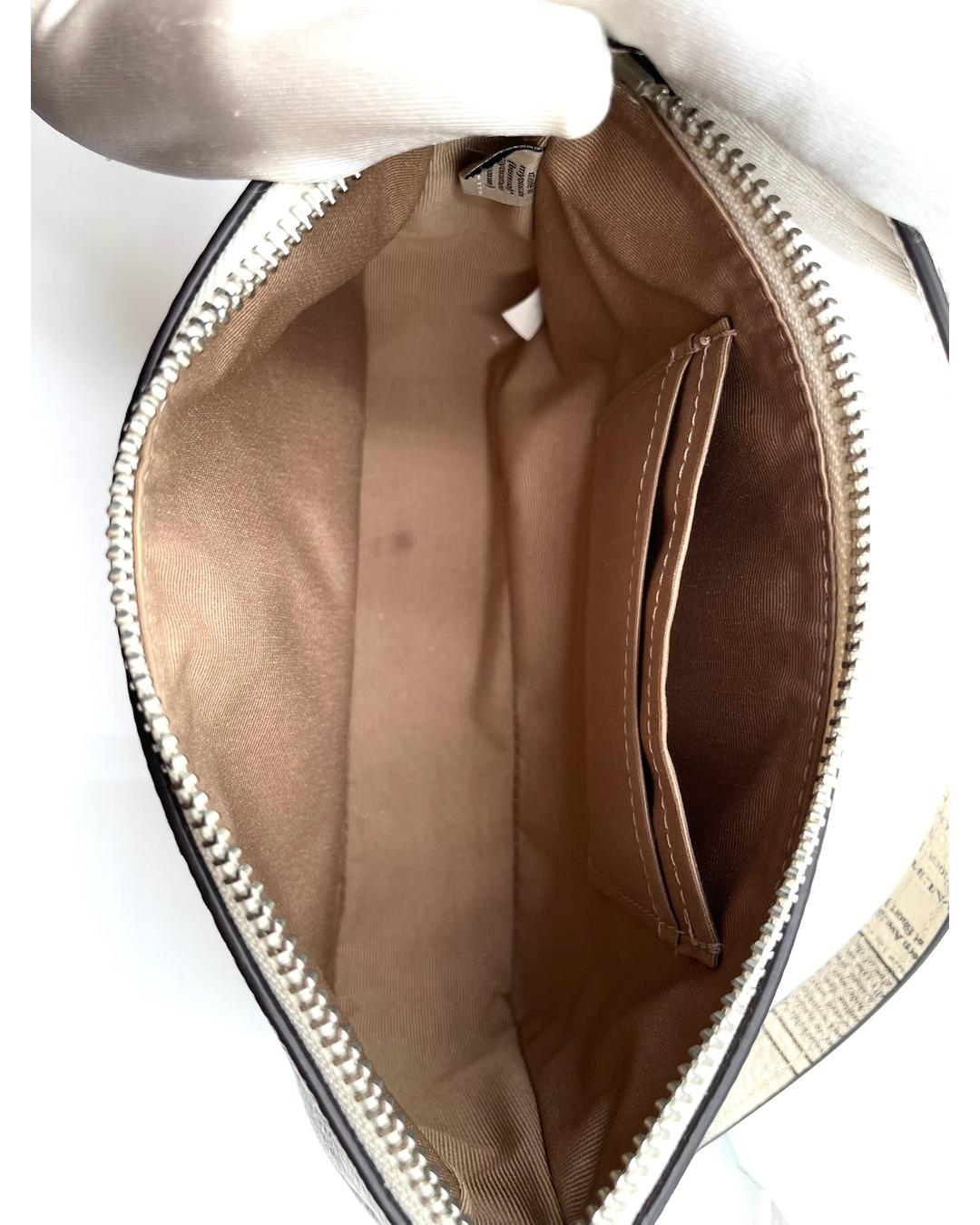 Interior of Coach Nolita 19 bag with brown fabric lining, credit card slots, and zip-top closure.