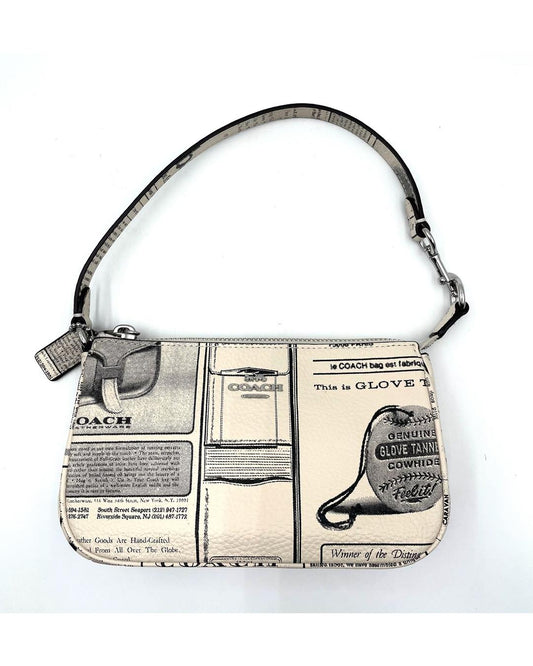 Coach Nolita 19 mini bag in cream pebble leather with black vintage newspaper print and a zip-top handle.