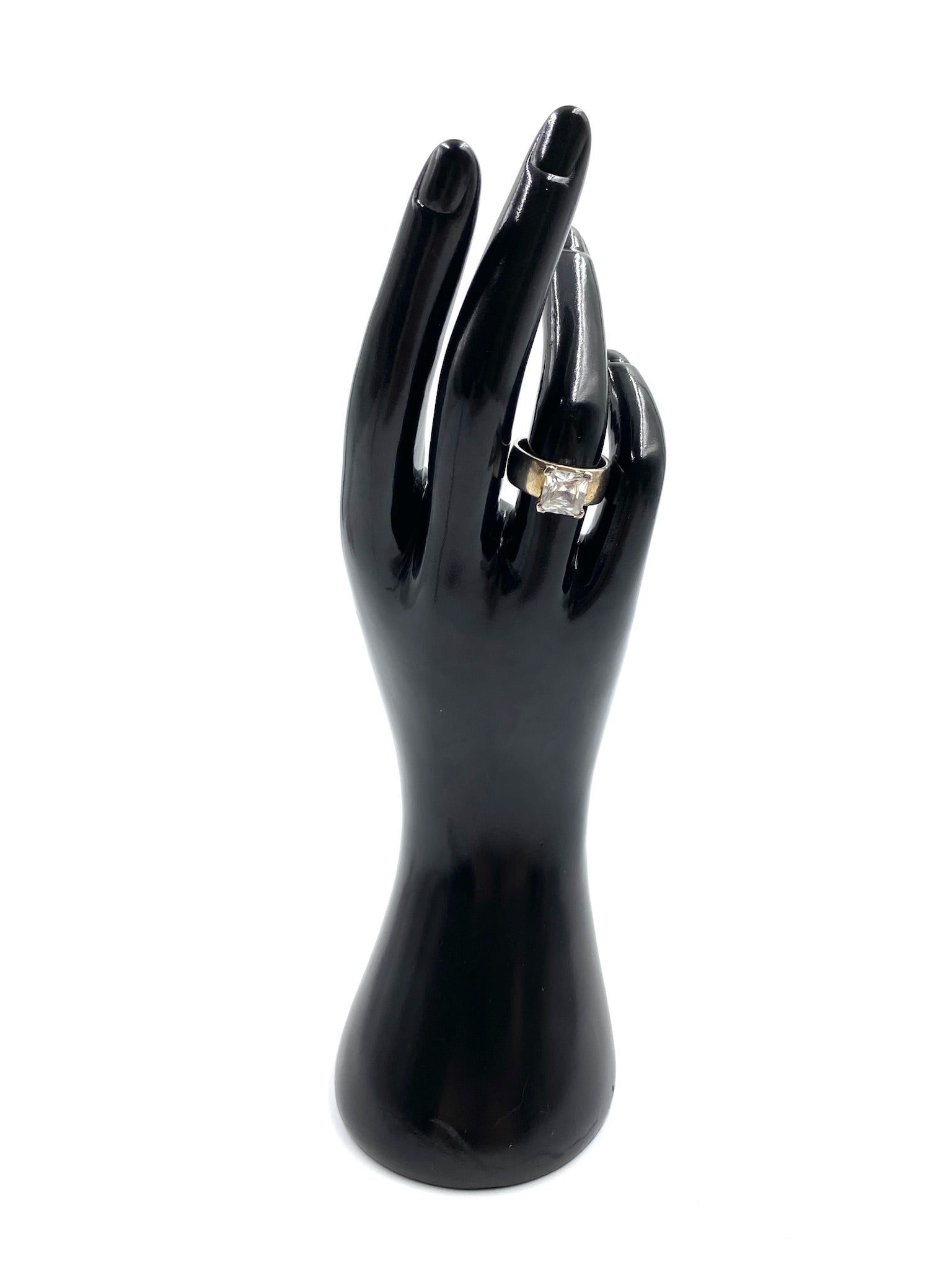 Sterling silver ring with a rectangular cubic zirconia stone on a black display hand.