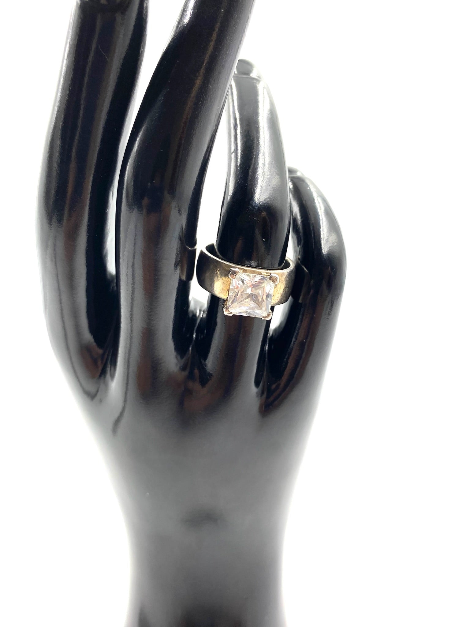 Sterling silver ring with a large, square cubic zirconia stone on a black display hand.
