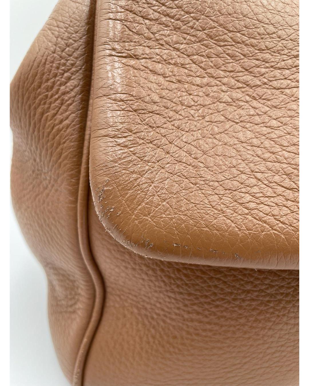 Close-up of caramel-colored calfskin Dolce & Gabbana Miss Sicily bag showing corner wear on the leather flap.