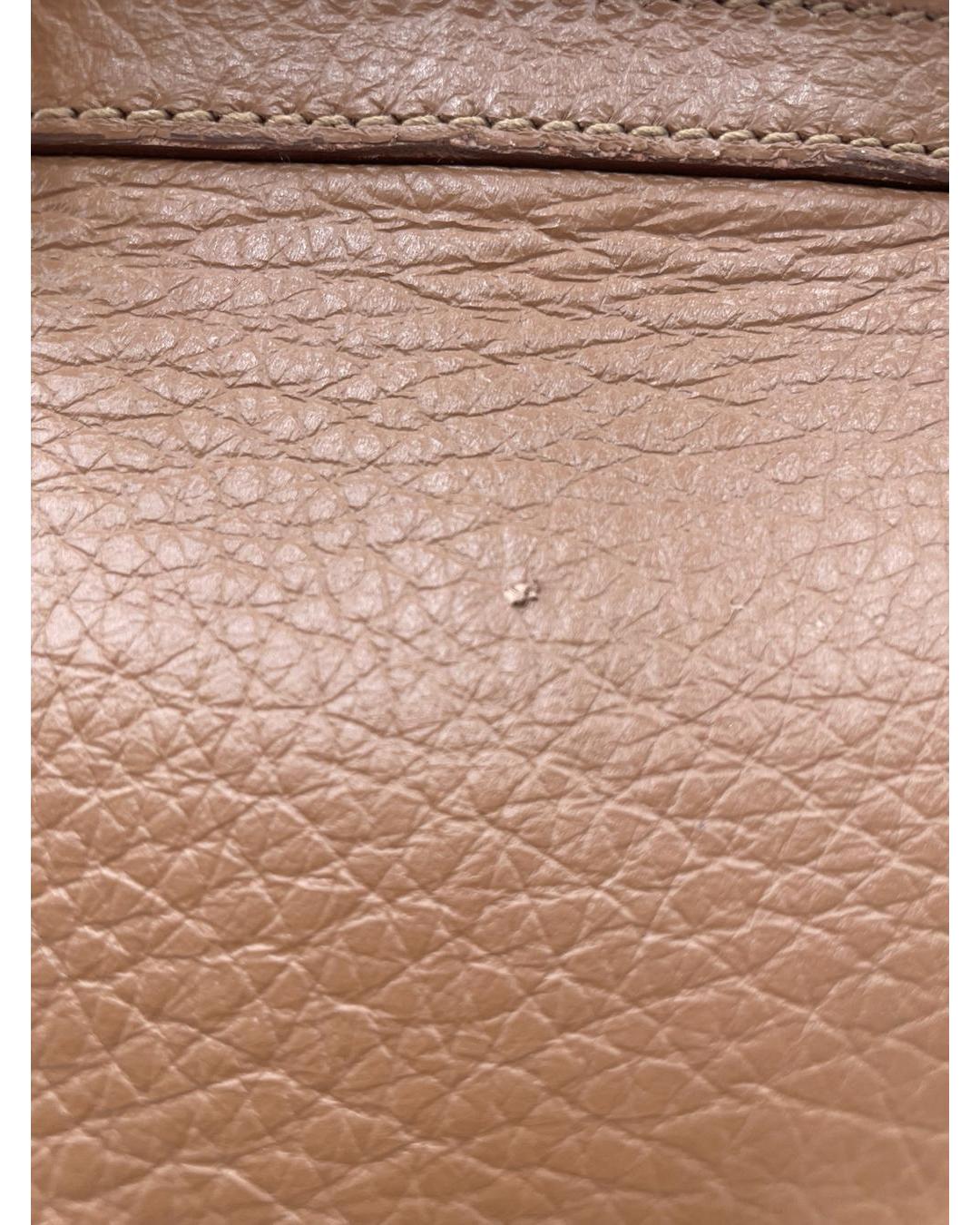 Close-up of caramel calfskin leather on a Dolce & Gabbana Miss Sicily bag showing minor surface wear and texture.