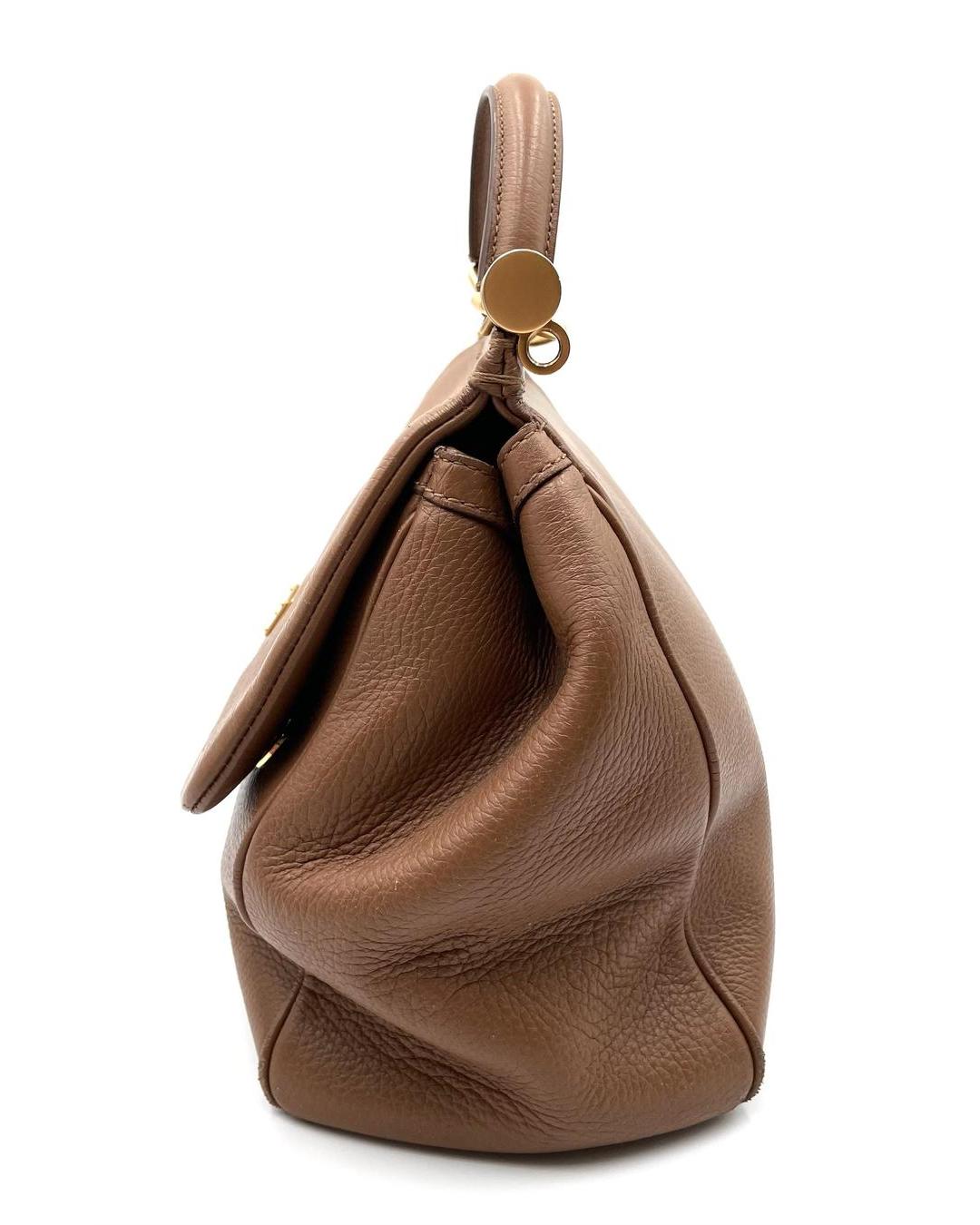 Side view of a large caramel-colored Dolce & Gabbana Miss Sicily calfskin top handle bag with gold hardware.