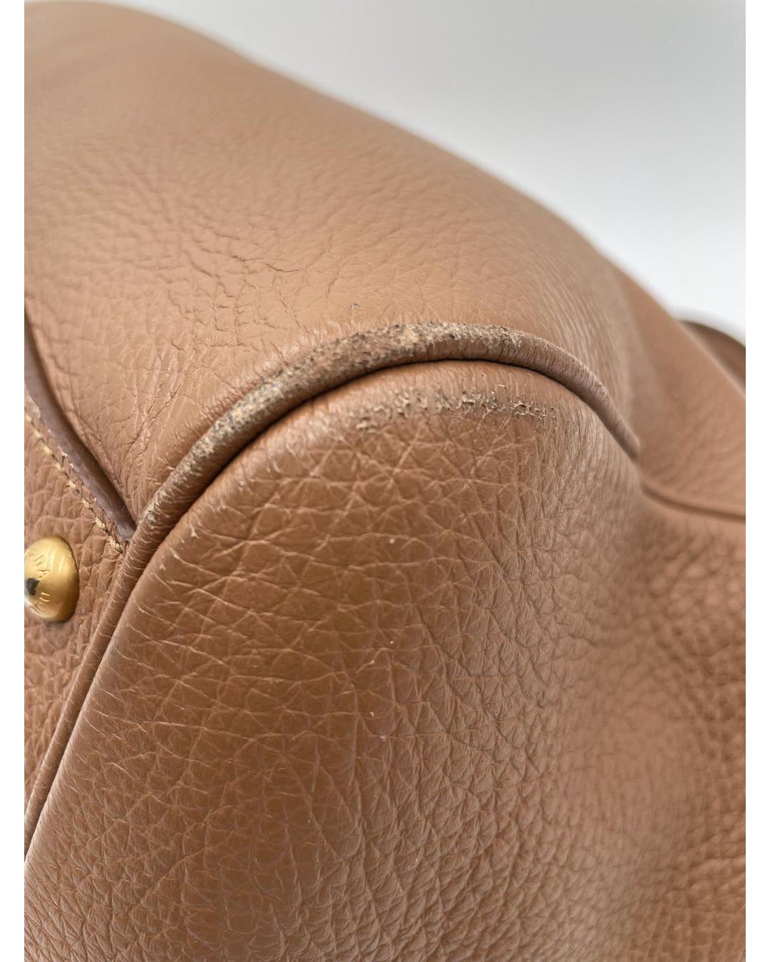 Close-up of caramel calfskin Dolce & Gabbana Miss Sicily bag showing corner wear and textured leather detail.