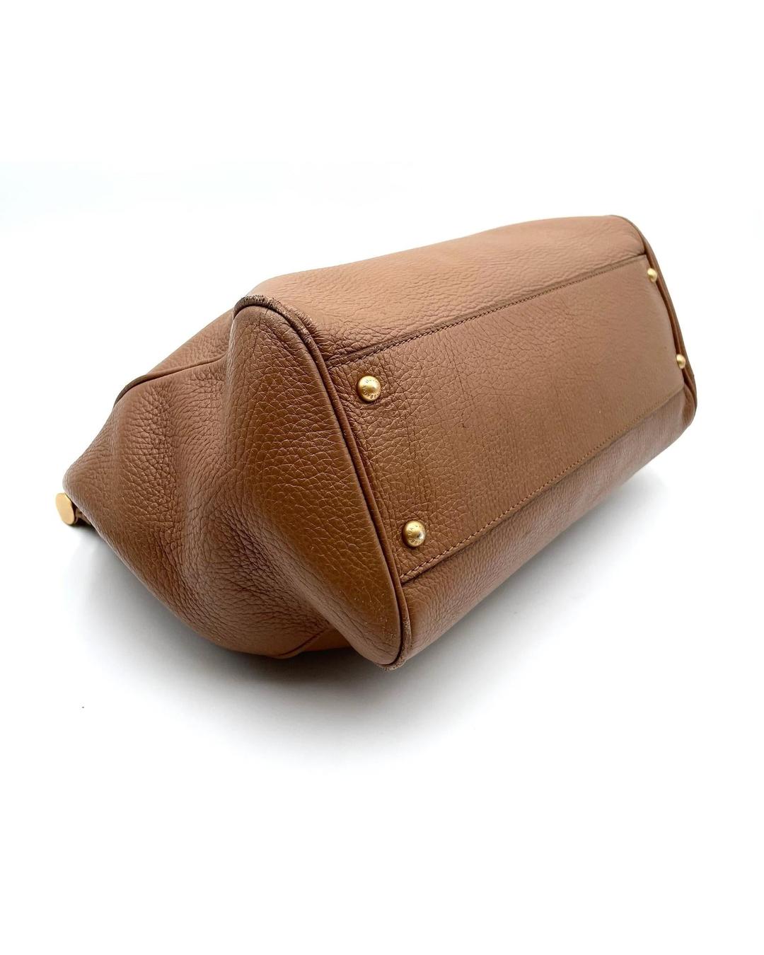 Caramel calfskin Dolce & Gabbana Miss Sicily bag, showing the textured leather base with protective gold-tone metal feet.