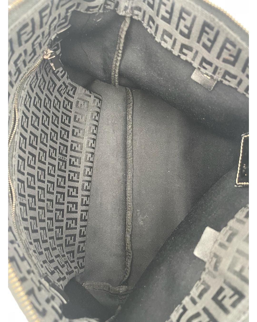 Interior of a black Fendi Zucca monogram shoulder tote featuring a fabric lining and a zippered side pocket.