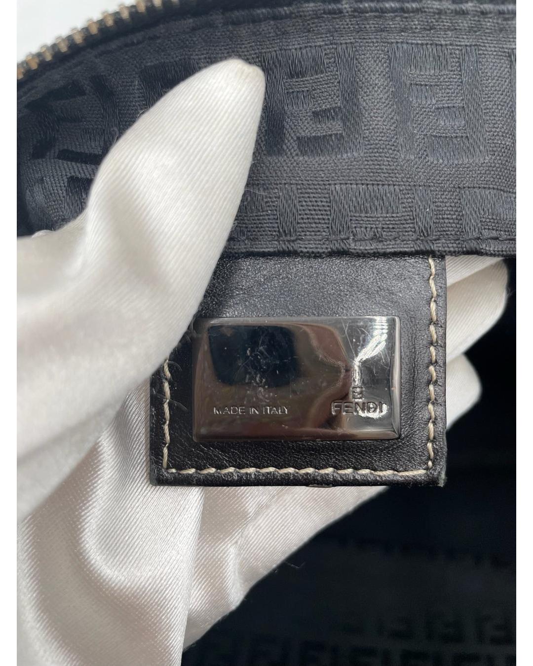 Close-up of Fendi black Zucca monogram fabric with a silver Made in Italy metal logo plaque inside the shoulder tote.