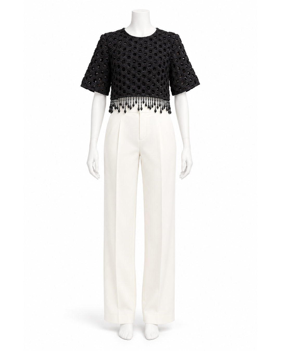Ganni black short-sleeve crop top with intricate beaded fringe hem on a mannequin.