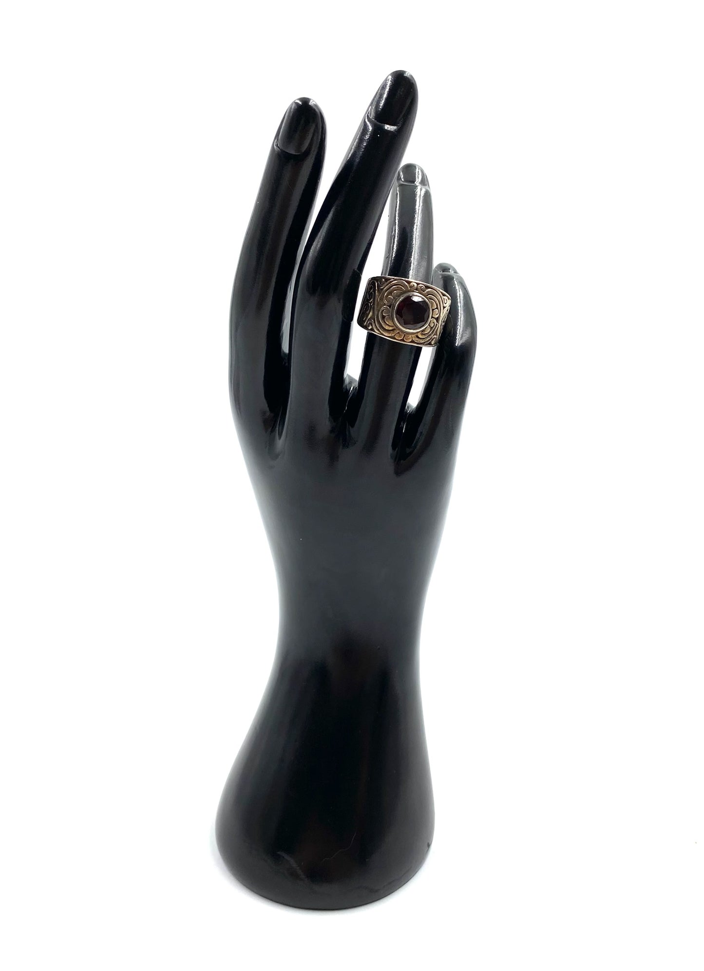 Garnet sterling silver ring size 6 with a wide band, displayed on a black hand model.