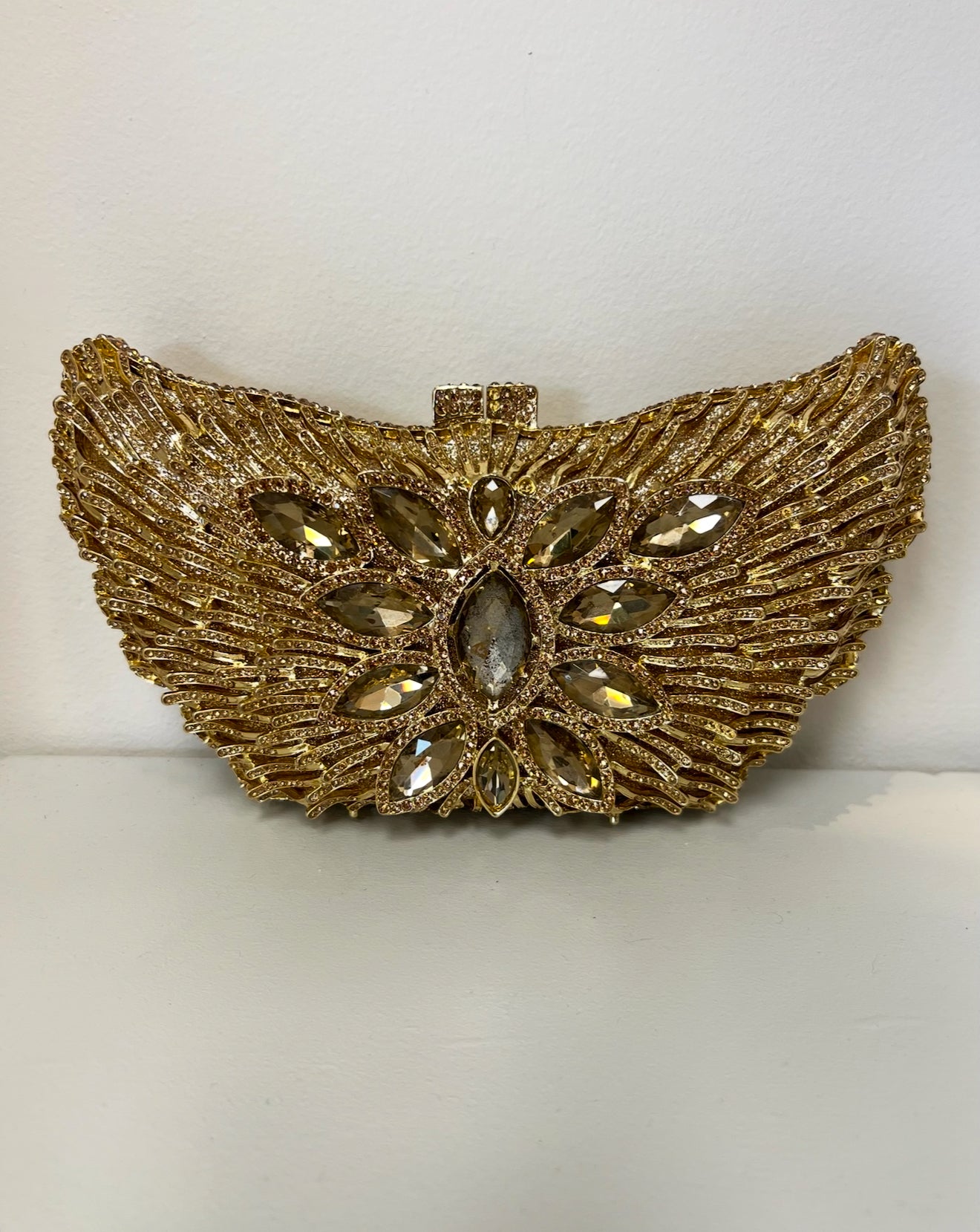 Gold butterfly-shaped clutch covered in textured metallic wings and sparkling crystal rhinestones.