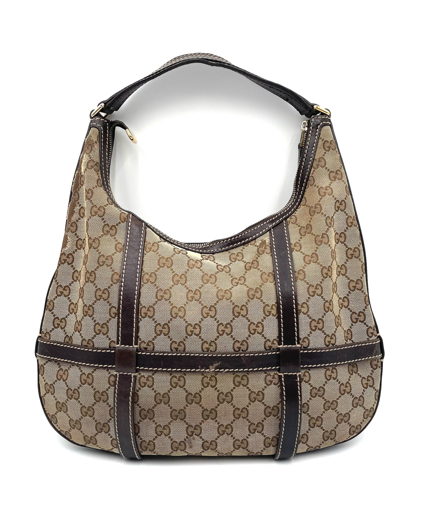 Gucci GG canvas hobo bag in beige and brown with dark leather trim, shoulder strap, and top zip closure.