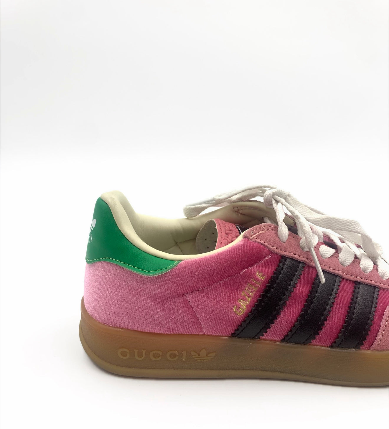 Gucci X Adidas Gazelle sneakers in pink suede with black stripes, green heel tab, and gum sole.