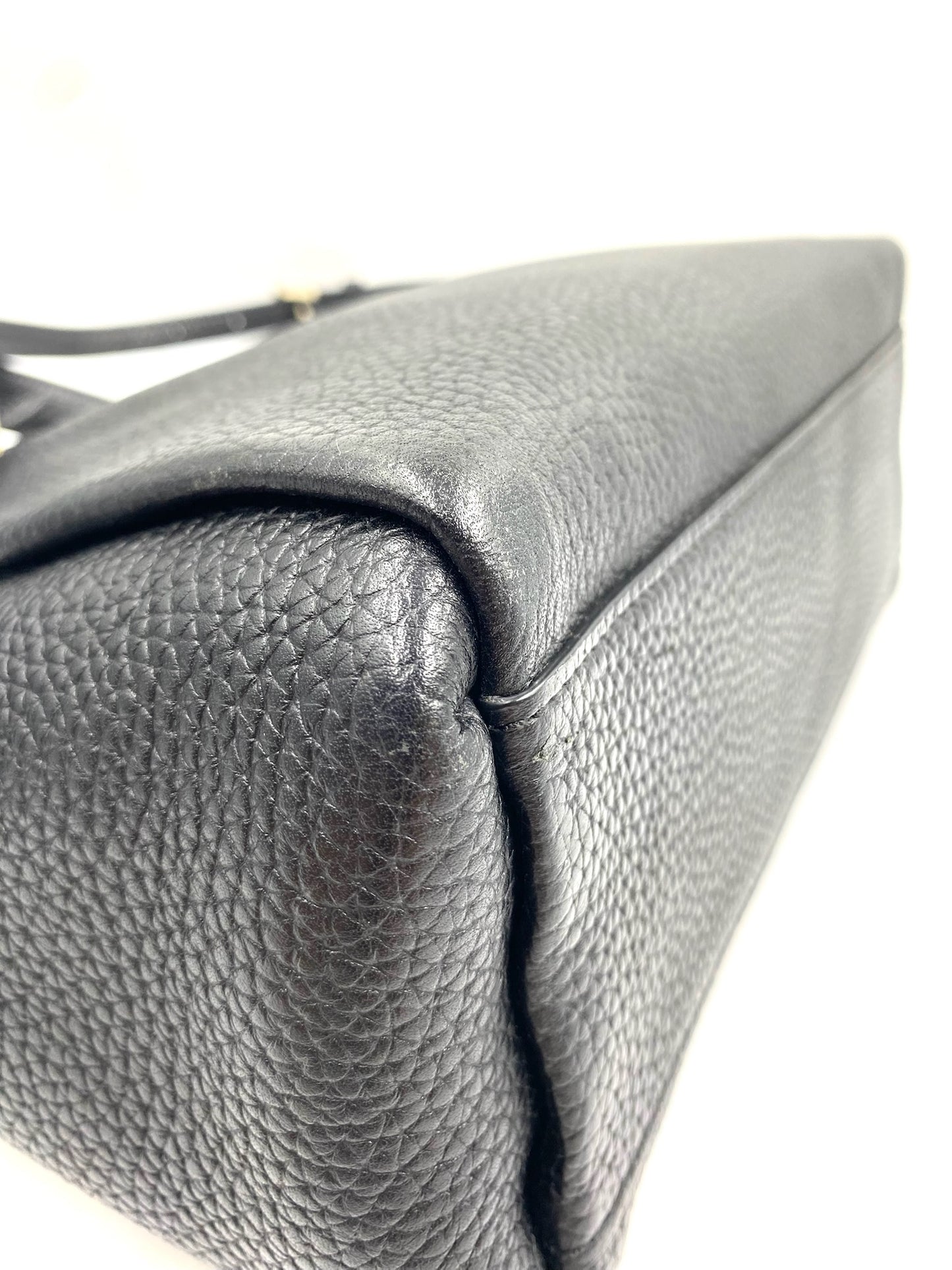 Kate Spade black pebbled leather tote bag, showing the side and top with a subtle gold accent.