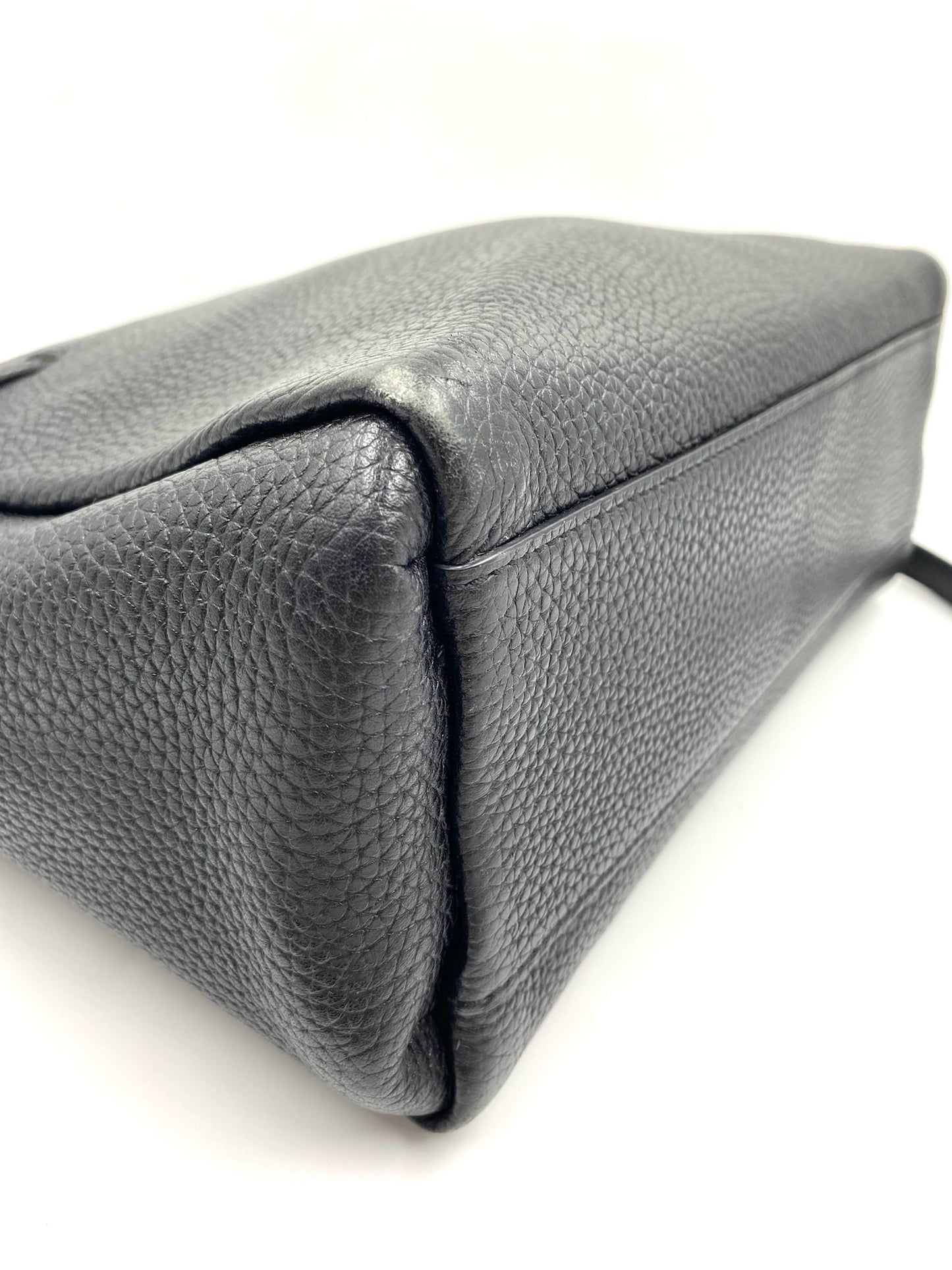 Kate Spade black pebbled leather tote bag, showing the side and bottom with a structured design.