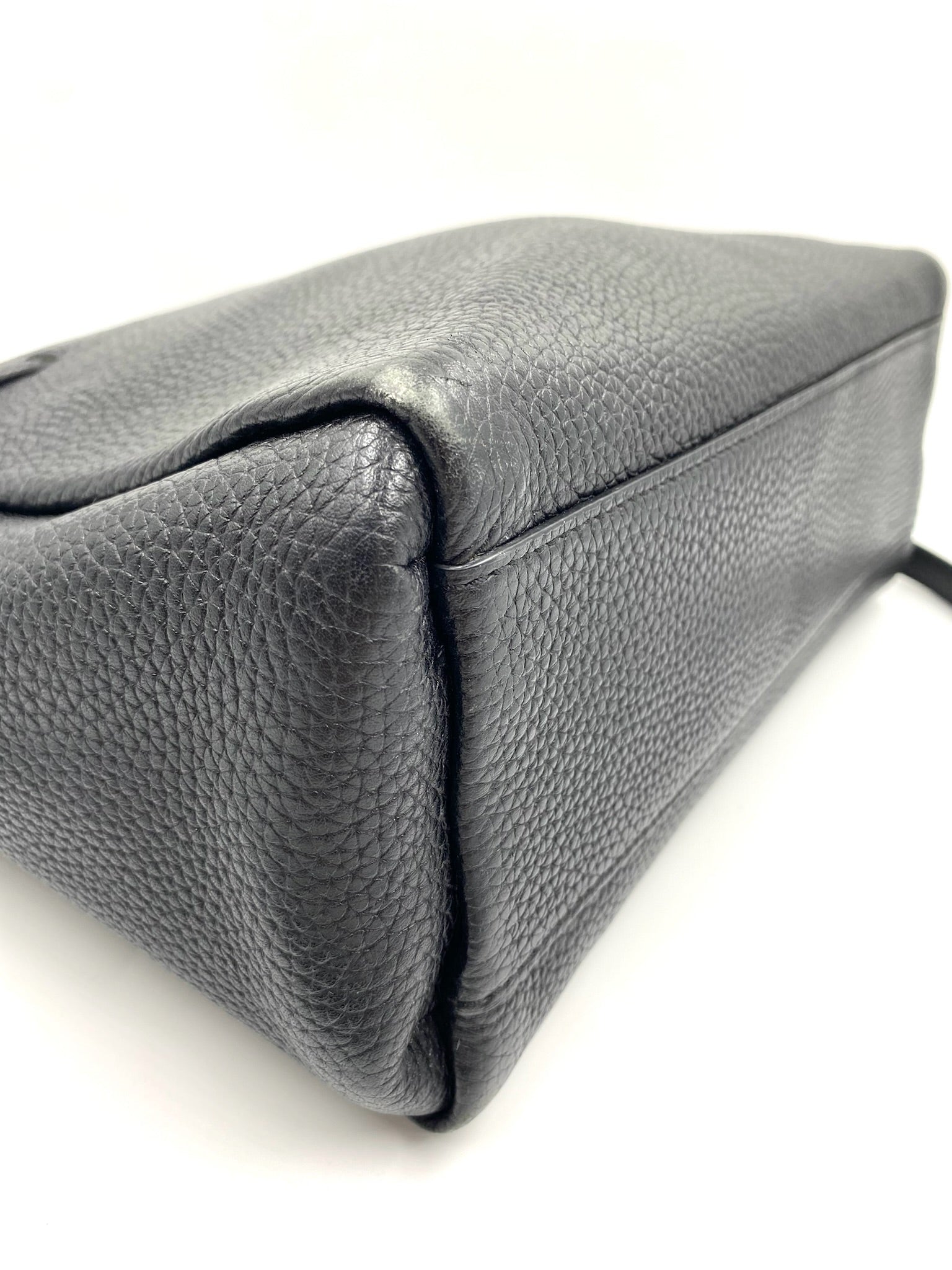 Kate Spade black pebbled leather tote bag, showing the side and bottom with a structured design.