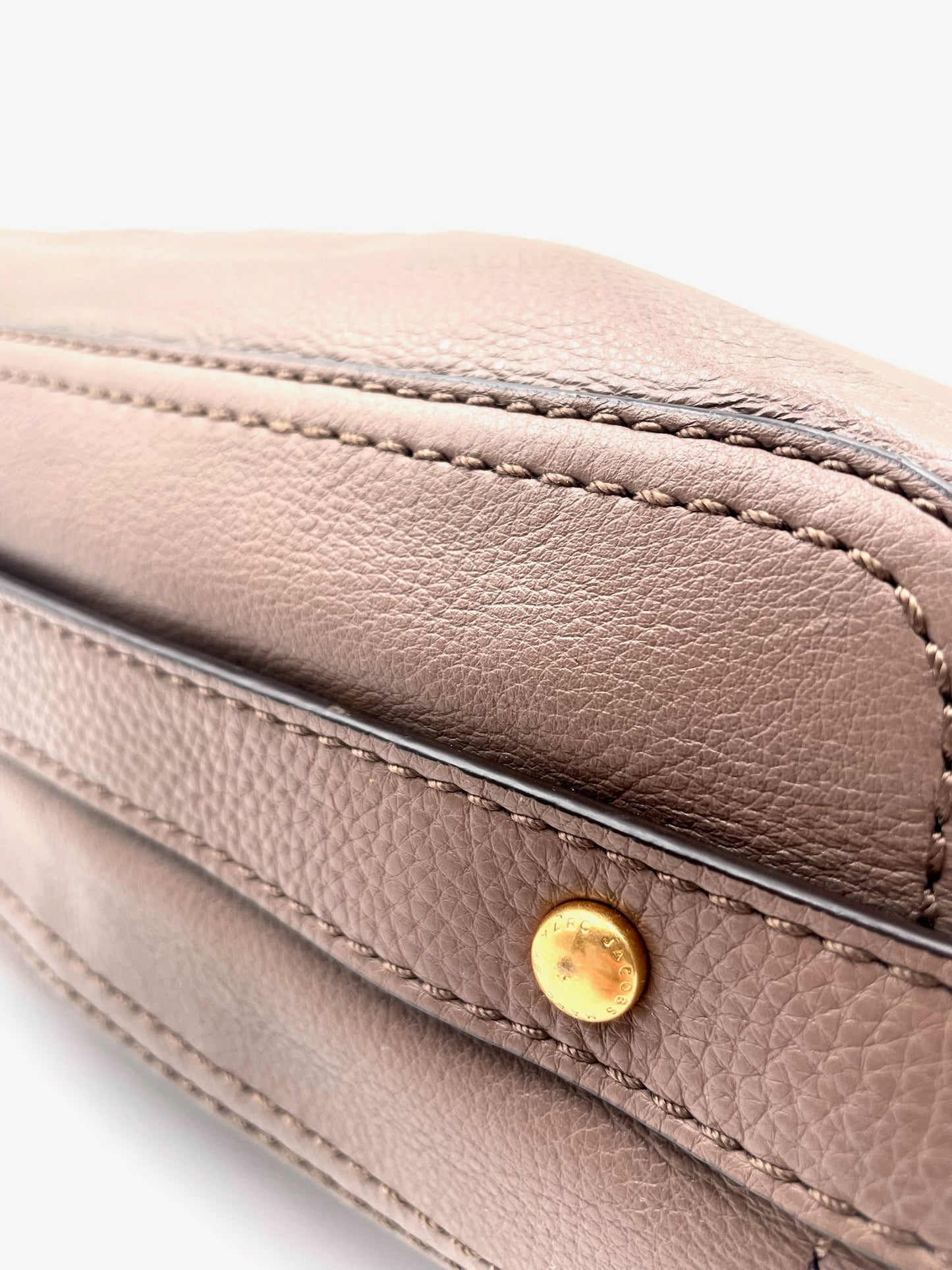 Marc Jacobs Revolution taupe leather hobo bag with gold-tone turn-lock closure and visible stitching.