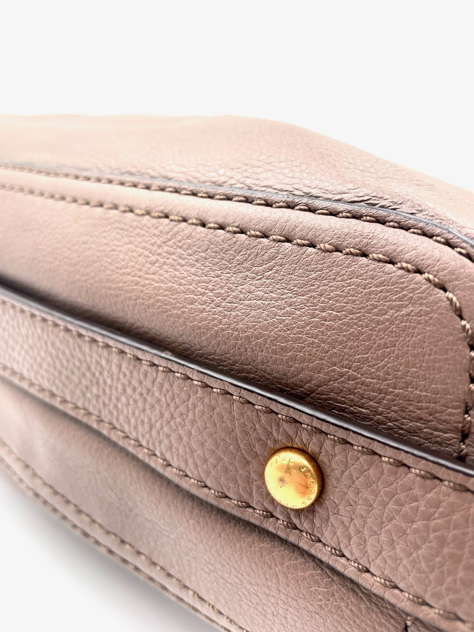 Marc Jacobs Revolution taupe leather hobo bag with gold-tone turn-lock closure and visible stitching.