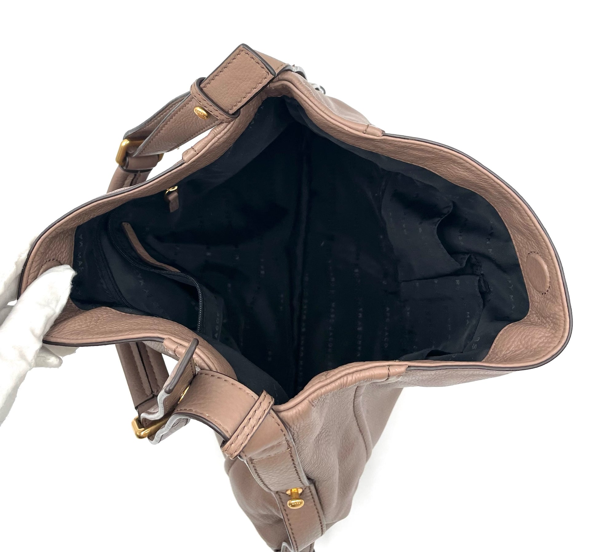 Marc Jacobs Revolution taupe leather hobo bag with open top, black interior, and gold hardware.