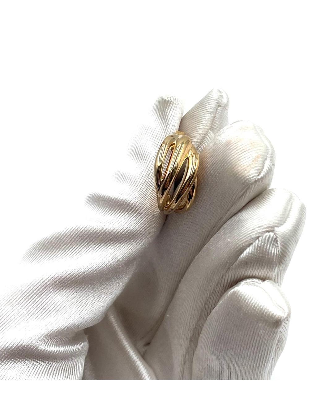 Mejuri gold-filled dome earring with a polished, curved, and ribbed design held in a white gloved hand.