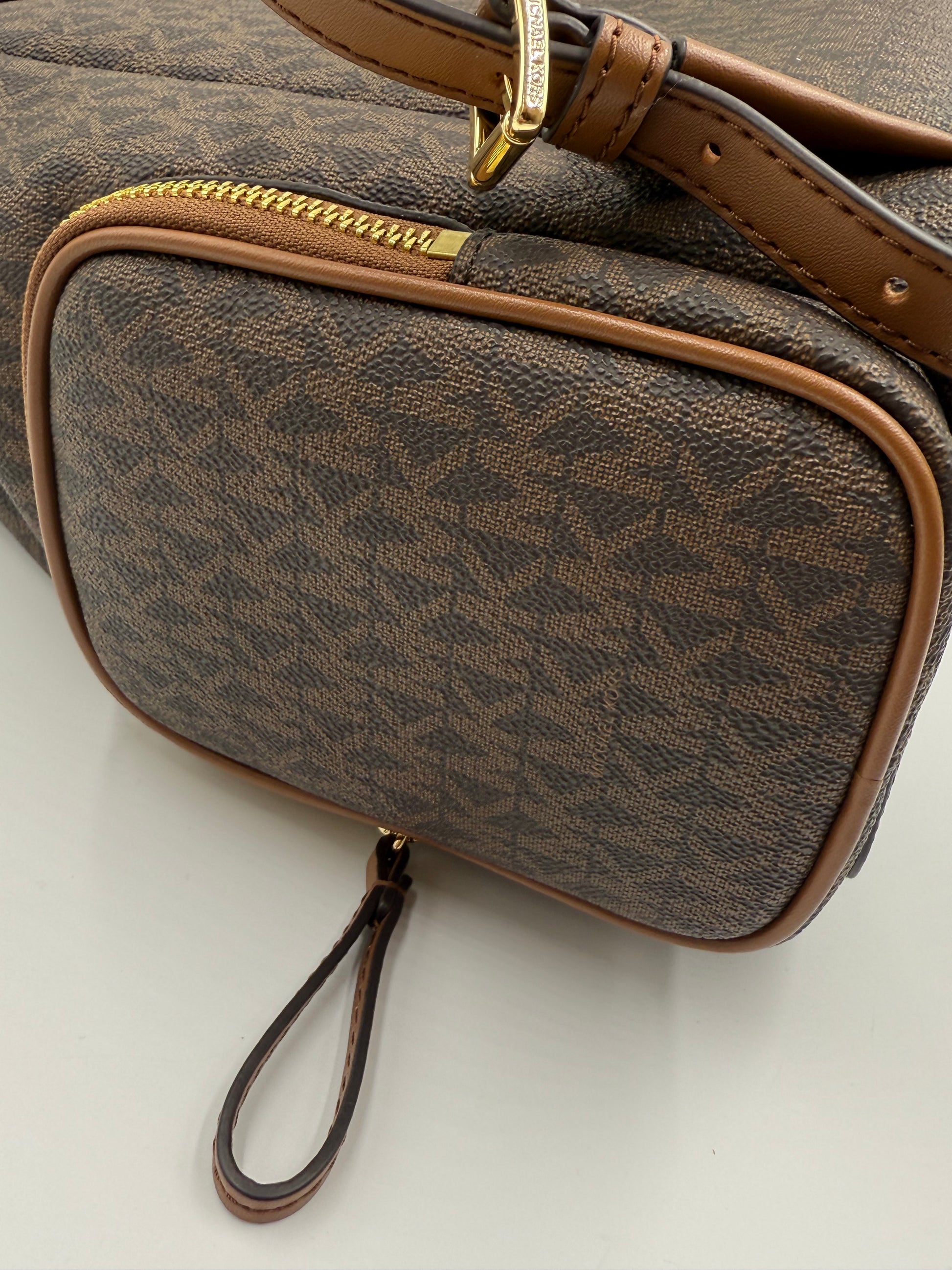 Michael Kors Large Logo Jet Set Backpack in brown monogram canvas with gold hardware and front zip pocket.